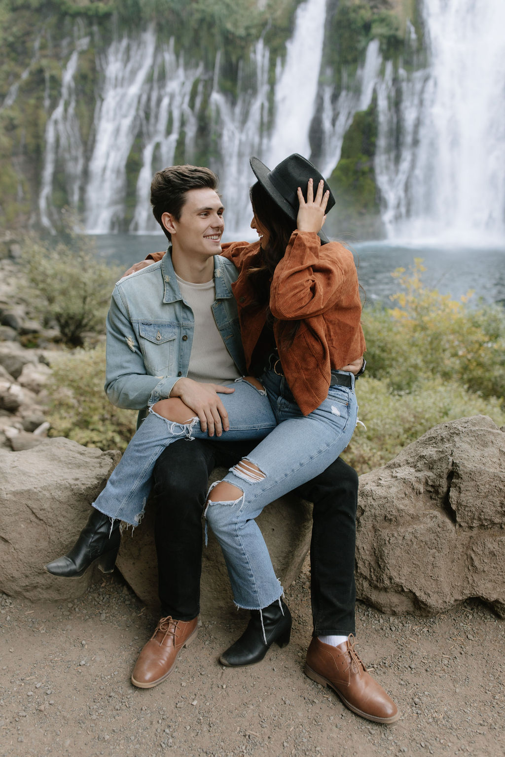 Girl sitting on her fiancees lap for engagement photos