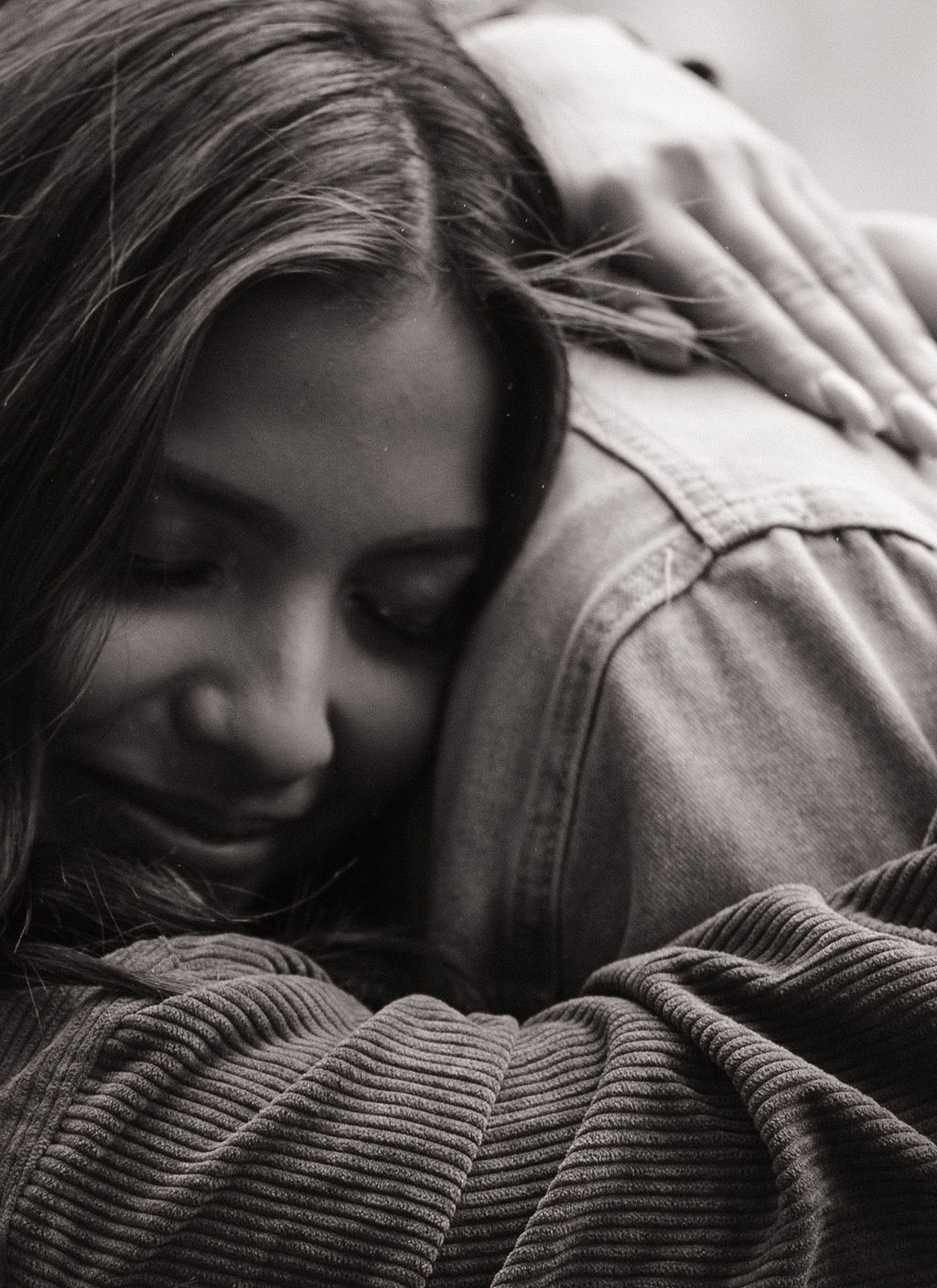Up close black and white photo of girl hugging her fiancé during engagement photos