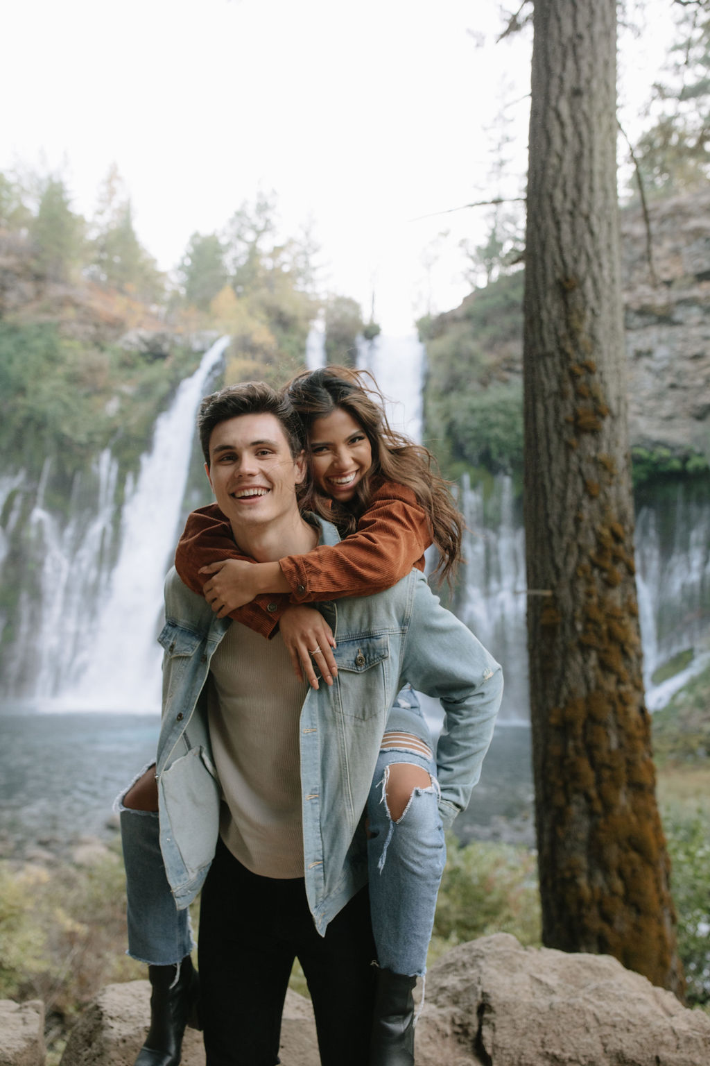 Girl on her fiancé's back at Burney falls photoshoot