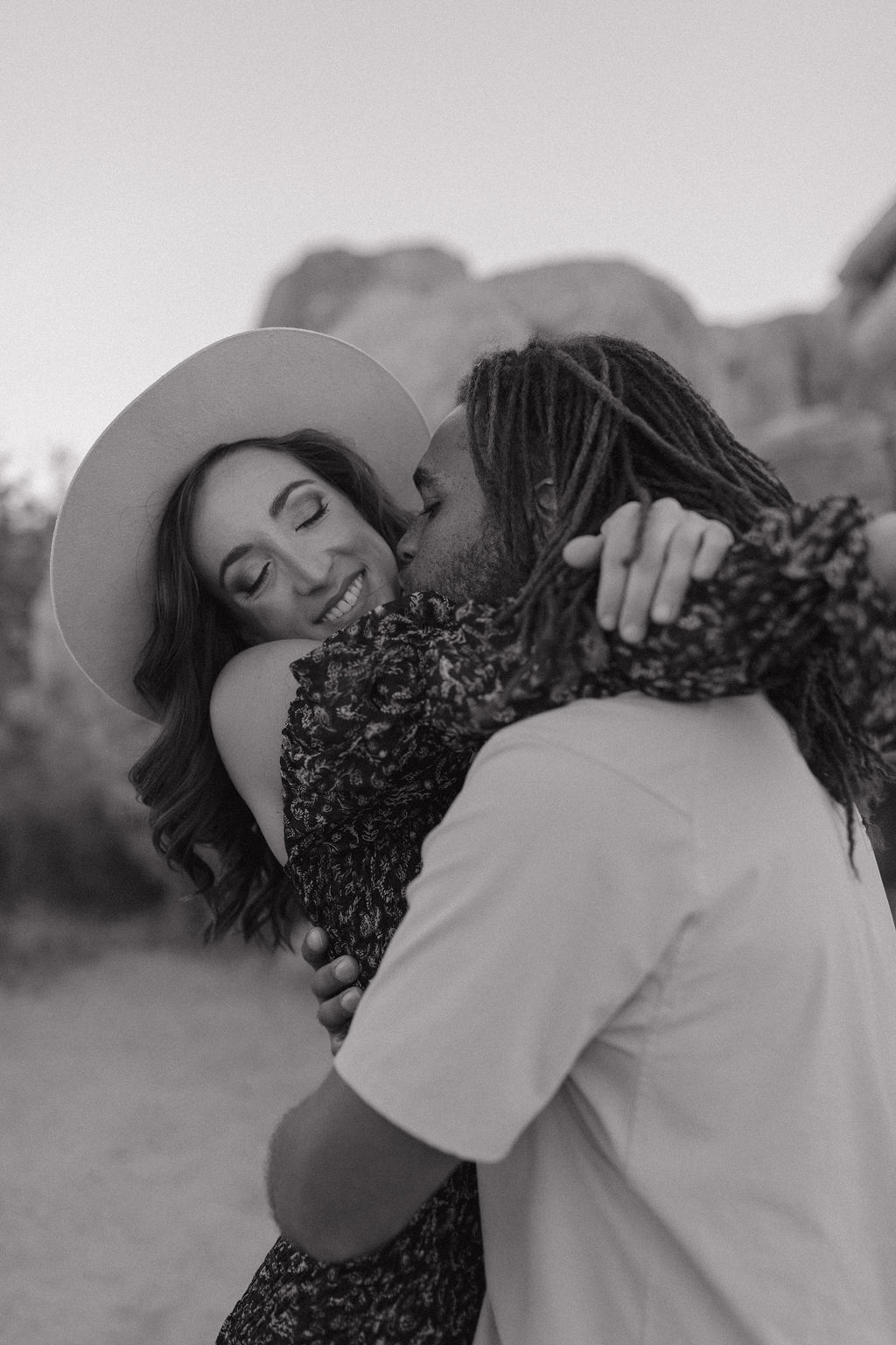 A man kissing his fiancee on the cheek