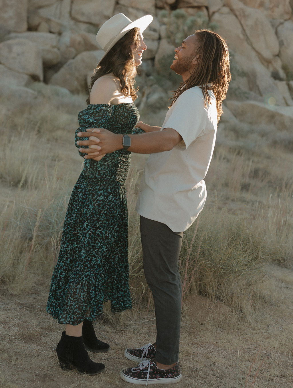A couple dancing in front of a rock formation for a Joshua tree photoshoot