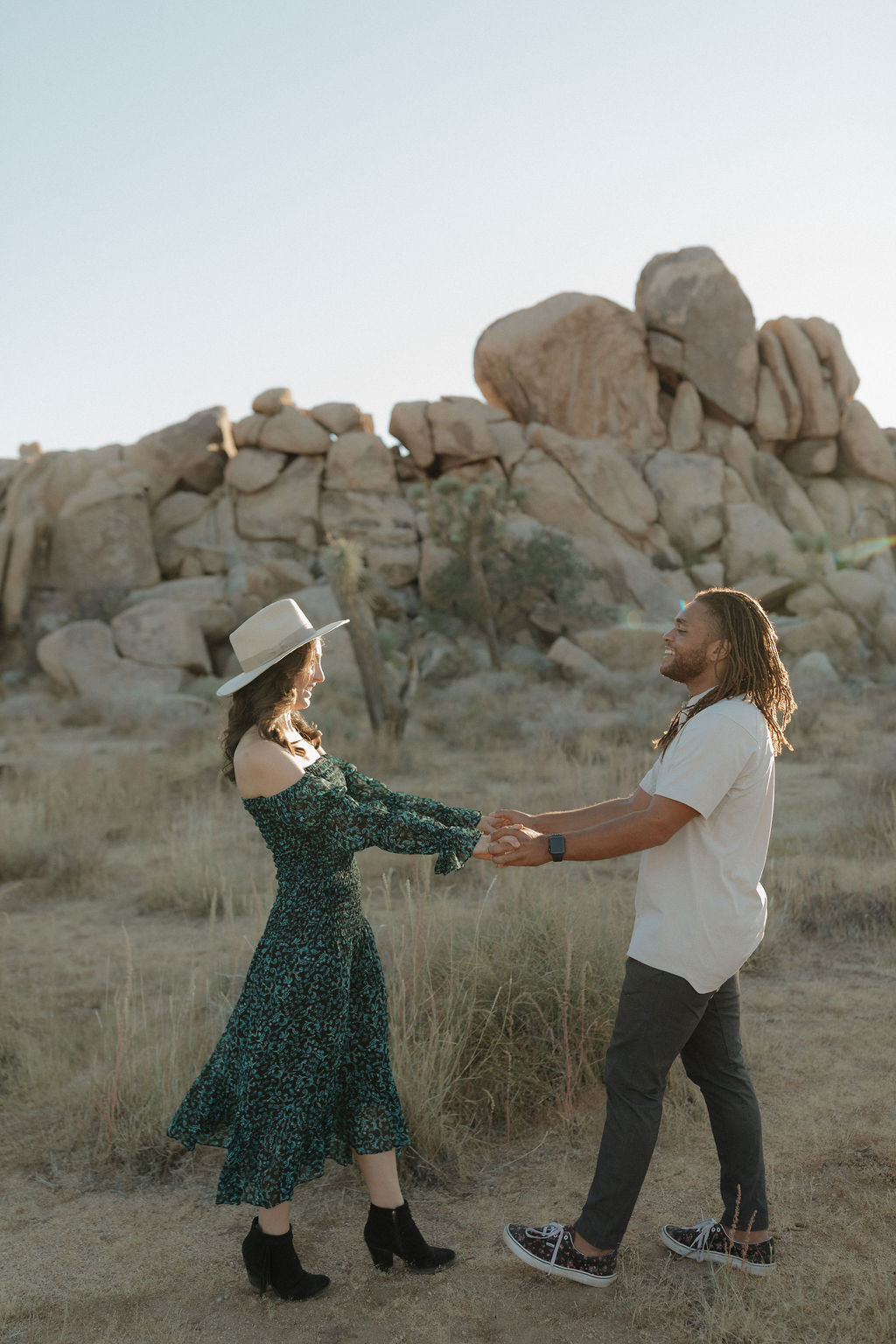 A couple dancing in front of a rock formation for a Joshua tree photoshoot