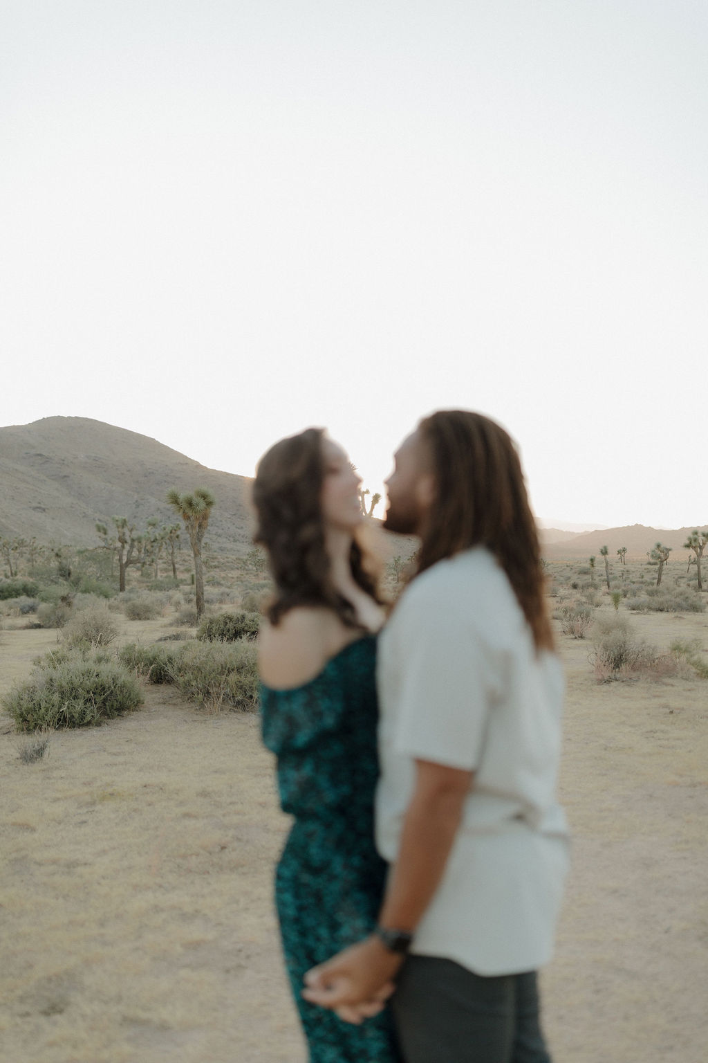 A couple posing for engagement photos in Joshua Tree