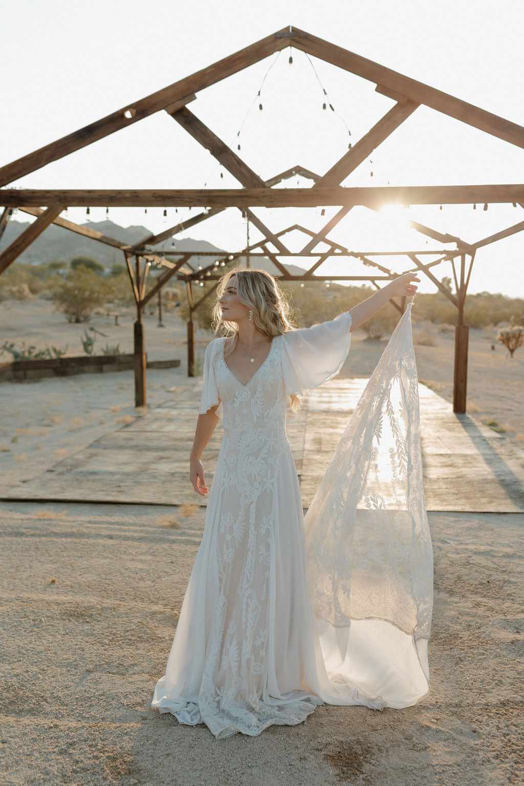 A bride holding up her dress at a boho wedding