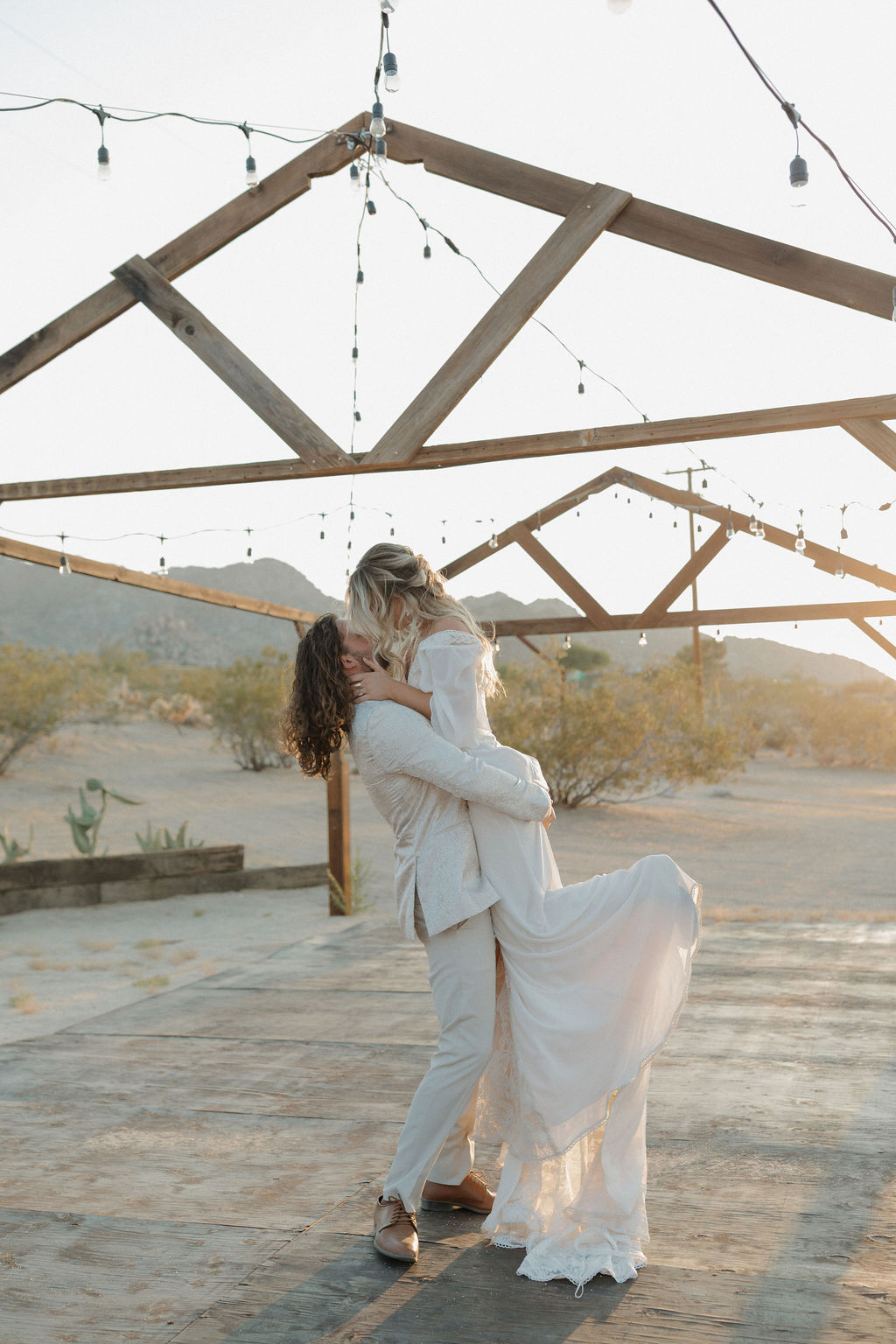 A bride and groom kissing at a boho wedding