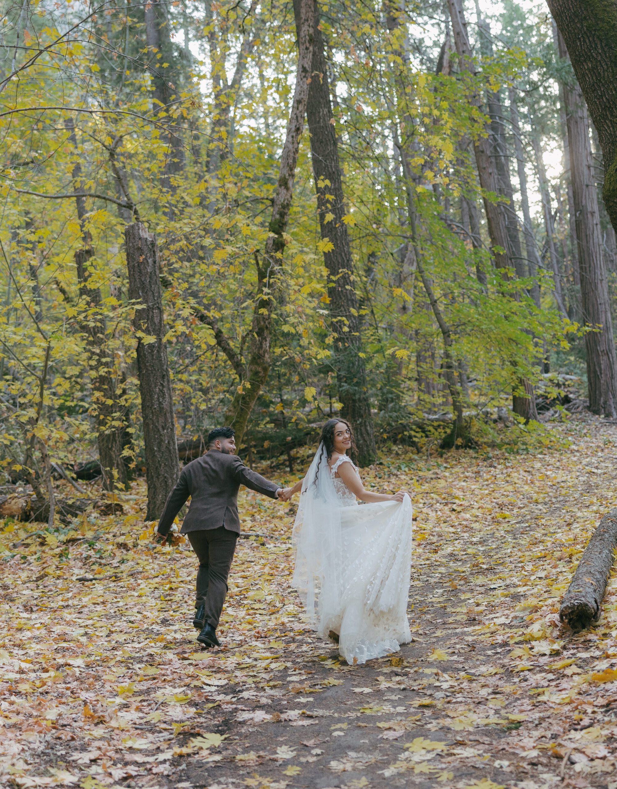 Bride and groom running away from camera in Yosemite National Park wedding