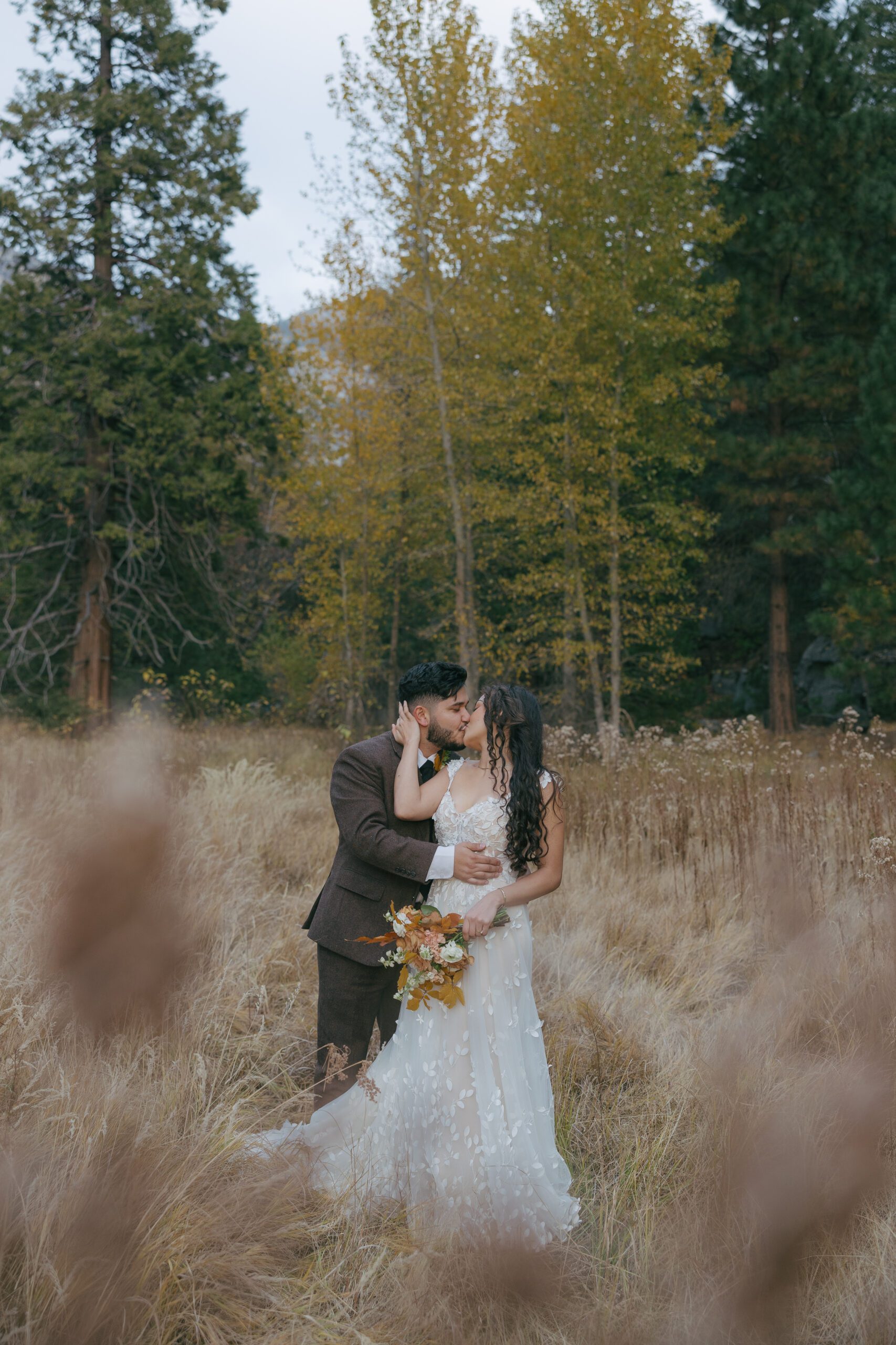 Bride and groom kissing in a field at their Yosemite Park wedding