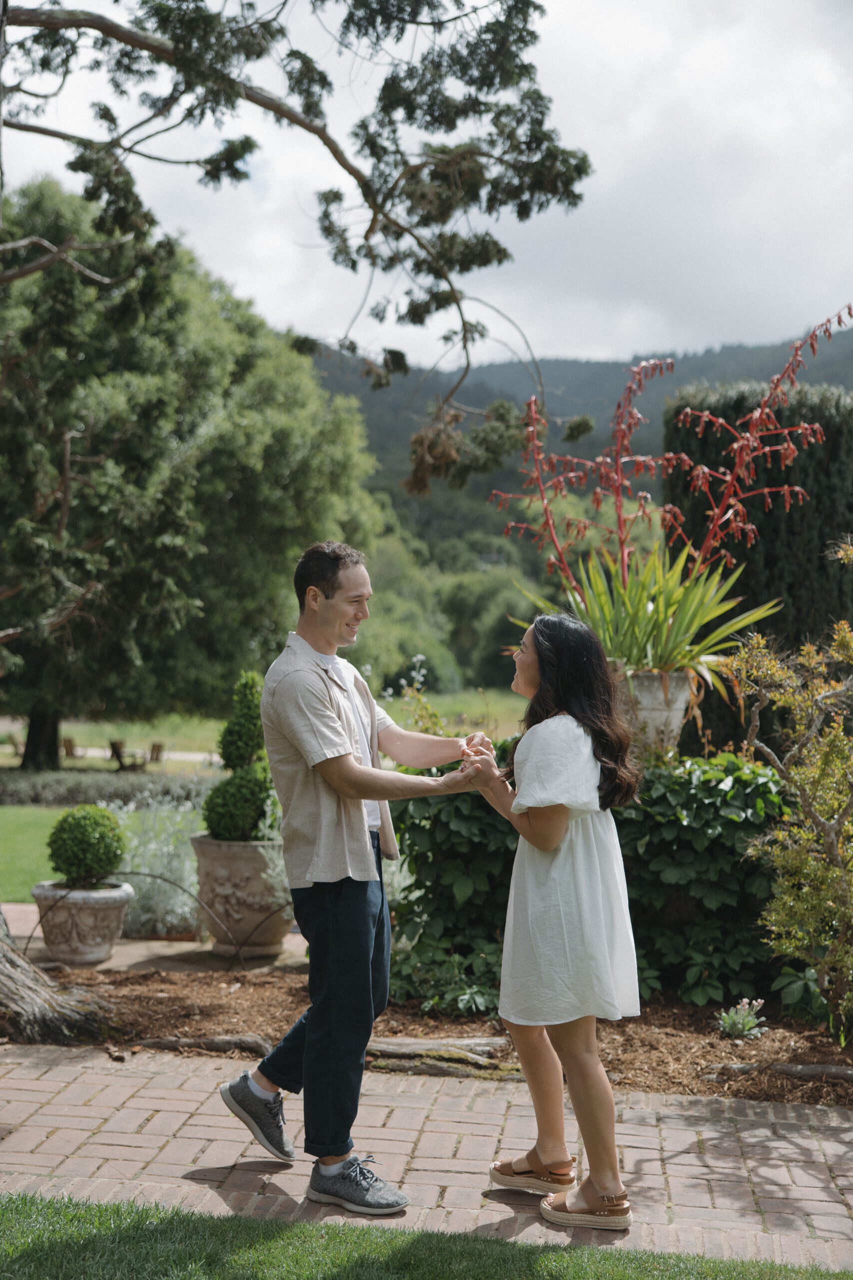 Couple facing each other holding hands in garden from Northern California engagement photoshoot