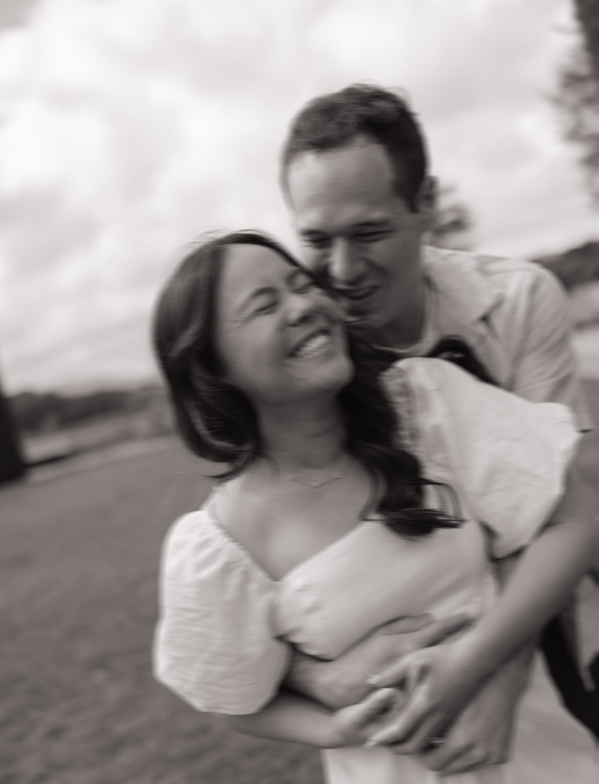 Blurry editorial engagement photo of couple laughing