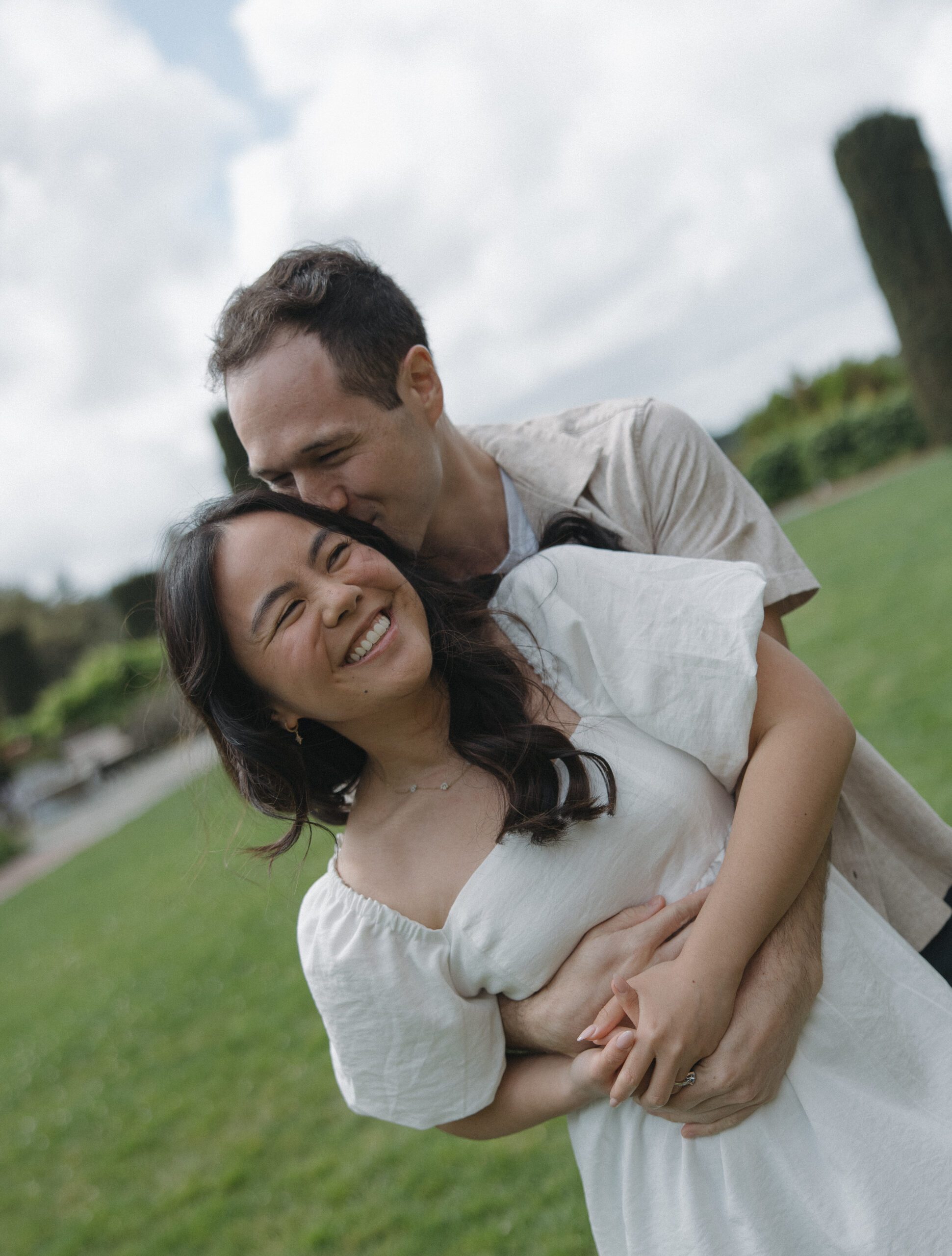 Bride laughing while being kissed during engagement photoshoot