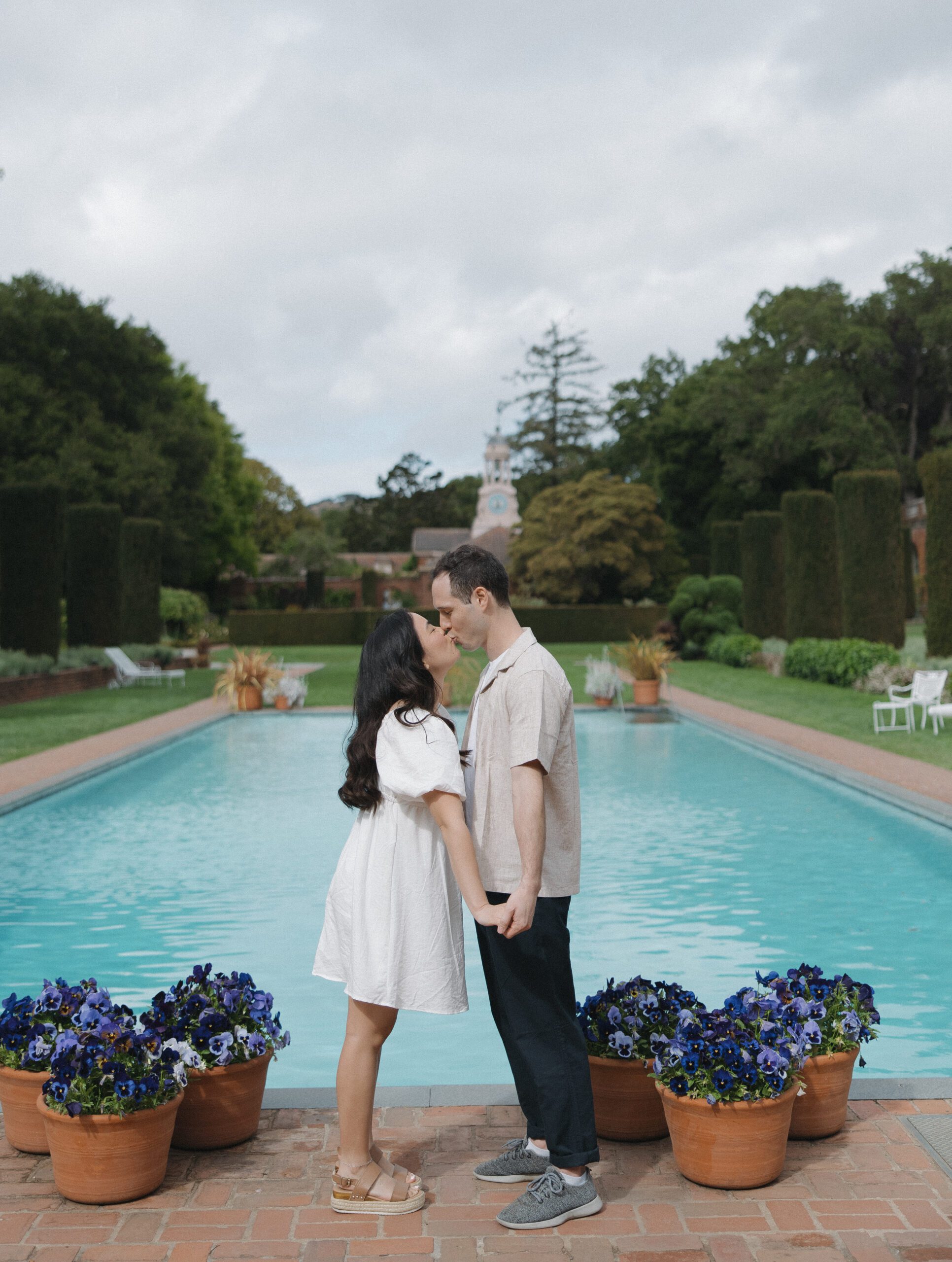 Couple kissing in front of pool at Bay Area engagement photoshoot