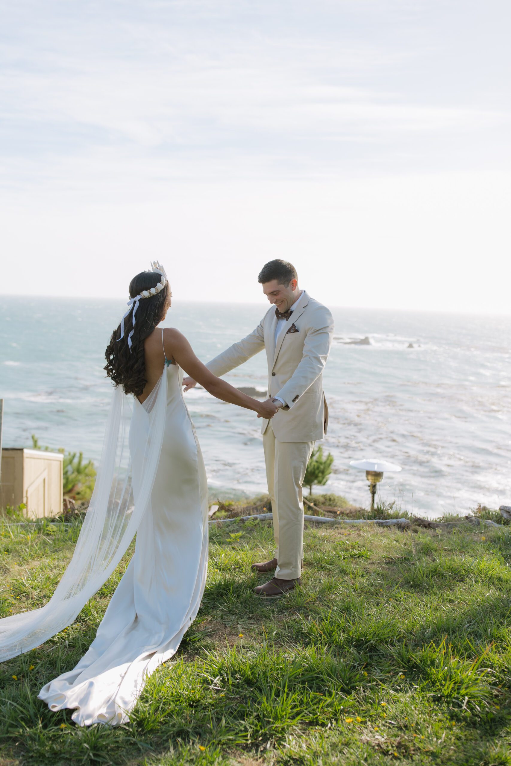 Bride and groom first look photos at waterfront beach wedding location