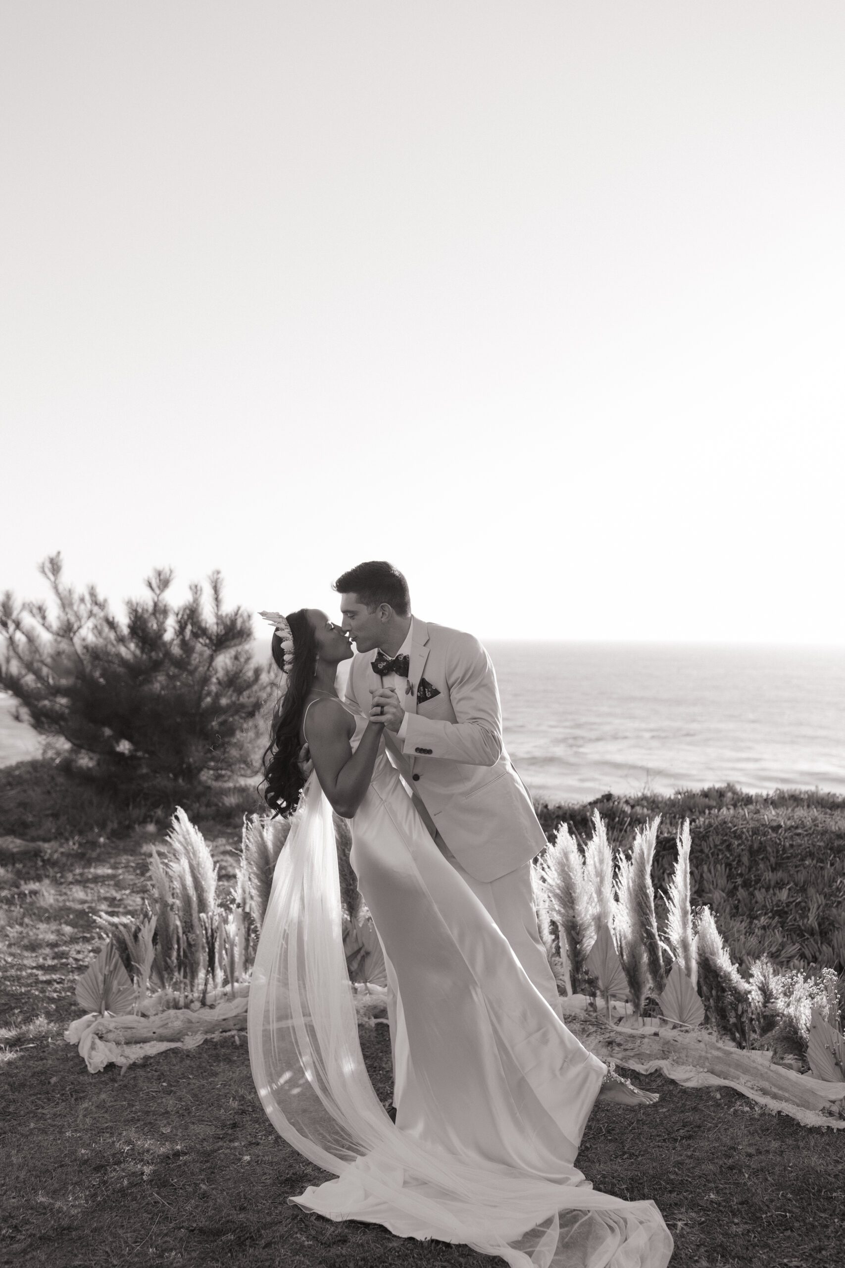 Black and white photo of bride and groom first kiss at Bay Area wedding ceremony