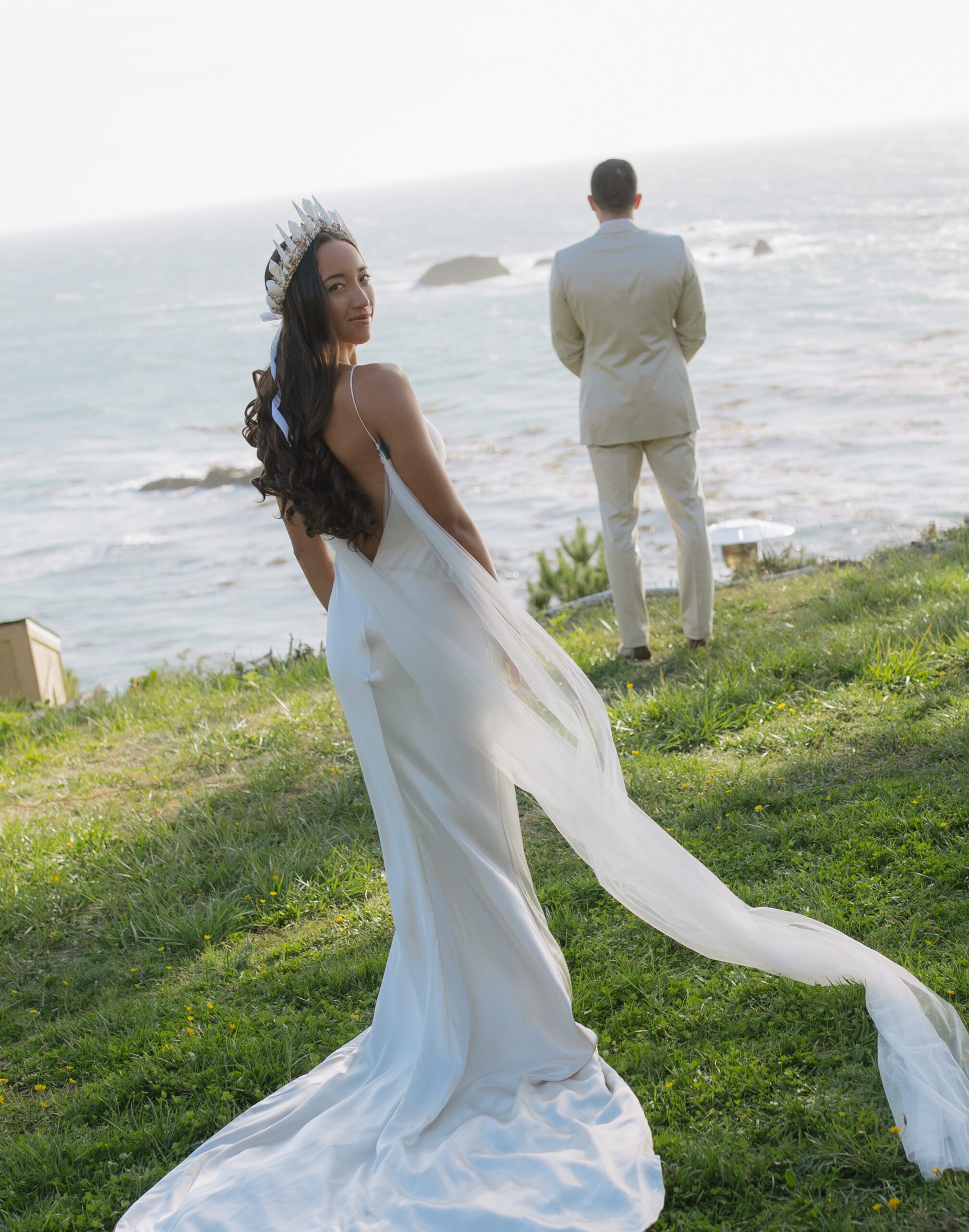 Bride and groom before first look with groom facing the ocean and bride facing the camera n a Bay Area cliff 