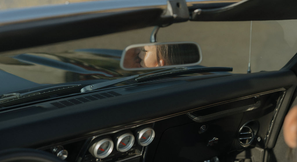 Couple kissing in classic car mirror for Bay Area engagement photos