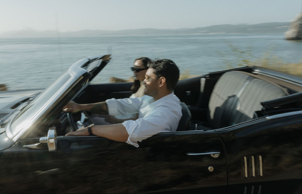 Blurry photo of couple driving classic car during engagement photos