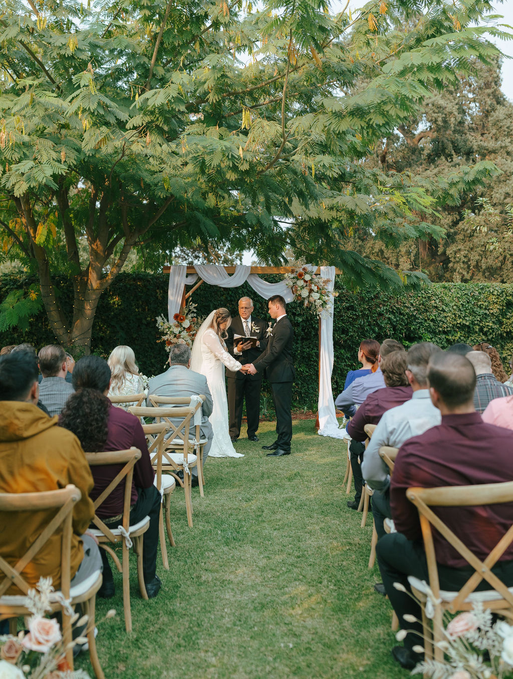 Wedding ceremony photo of bride and groom holding hands praying