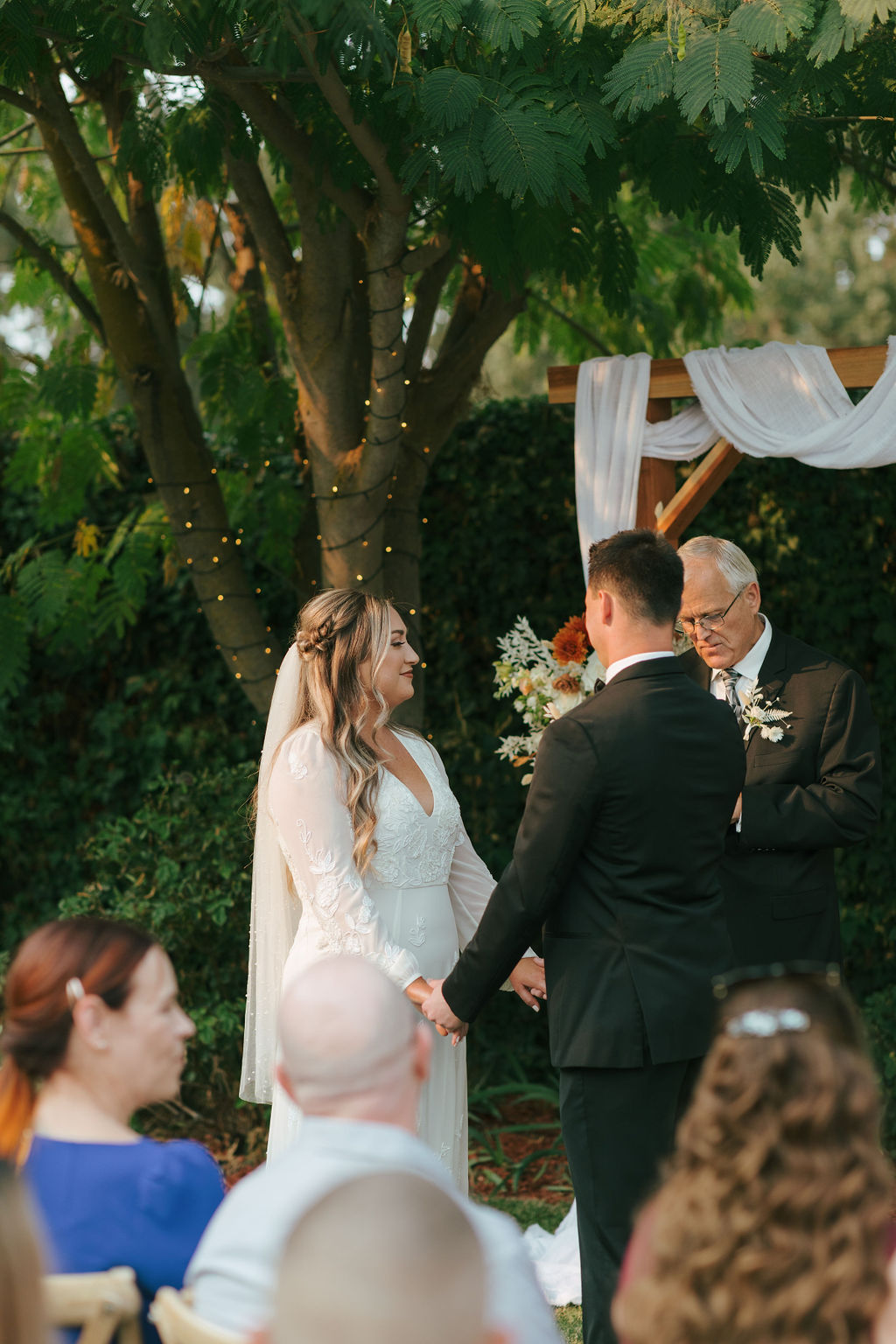 Bride and groom holding hands at their ceremony site during their intimate wedding