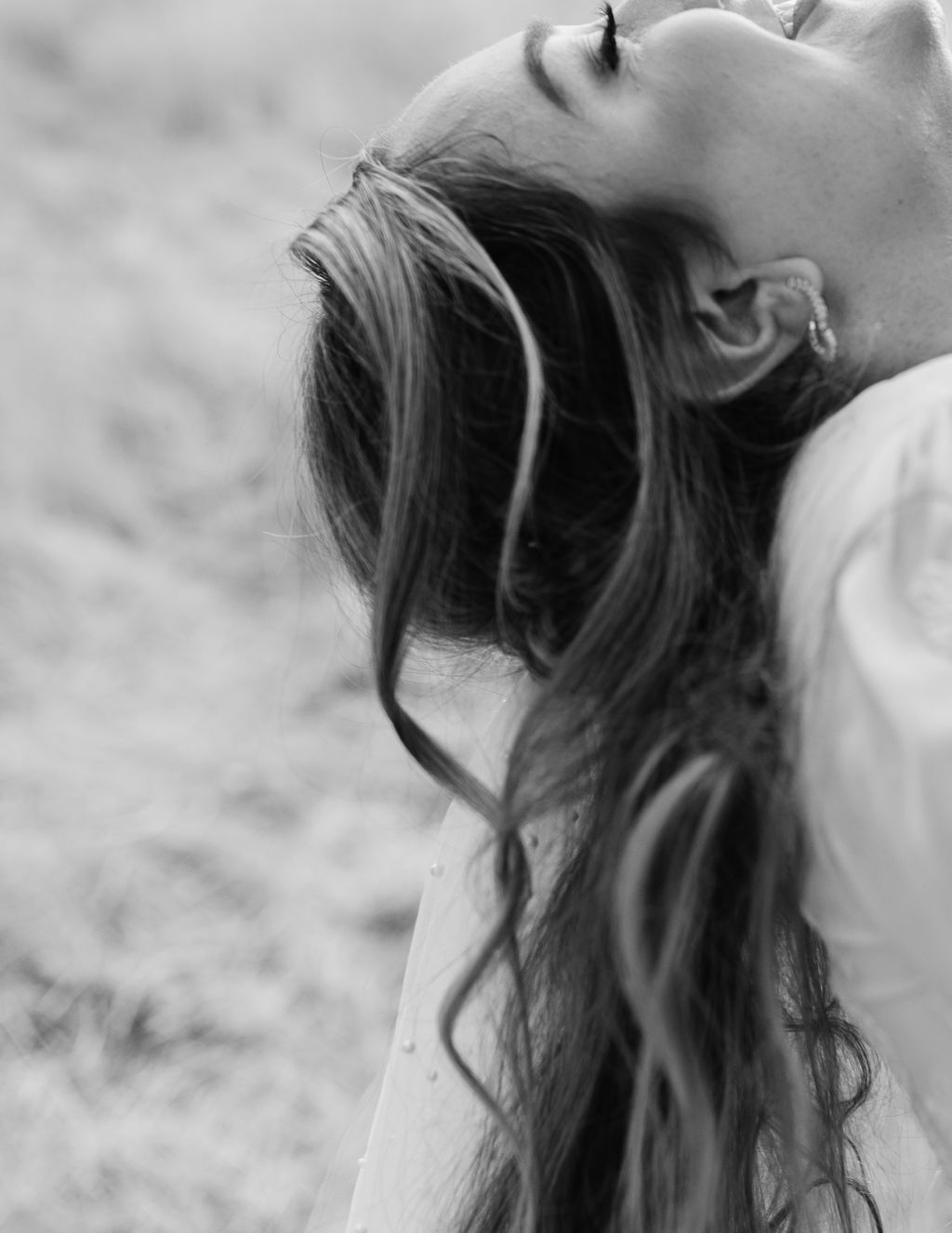 Editorial wedding photo of bride throwing her head back laughing