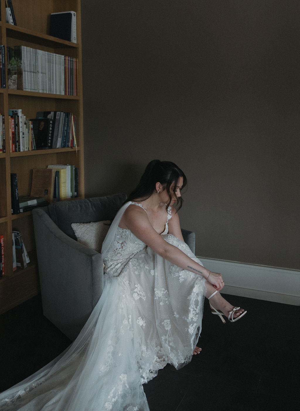 Bride getting ready photos where she is tightening her shoe