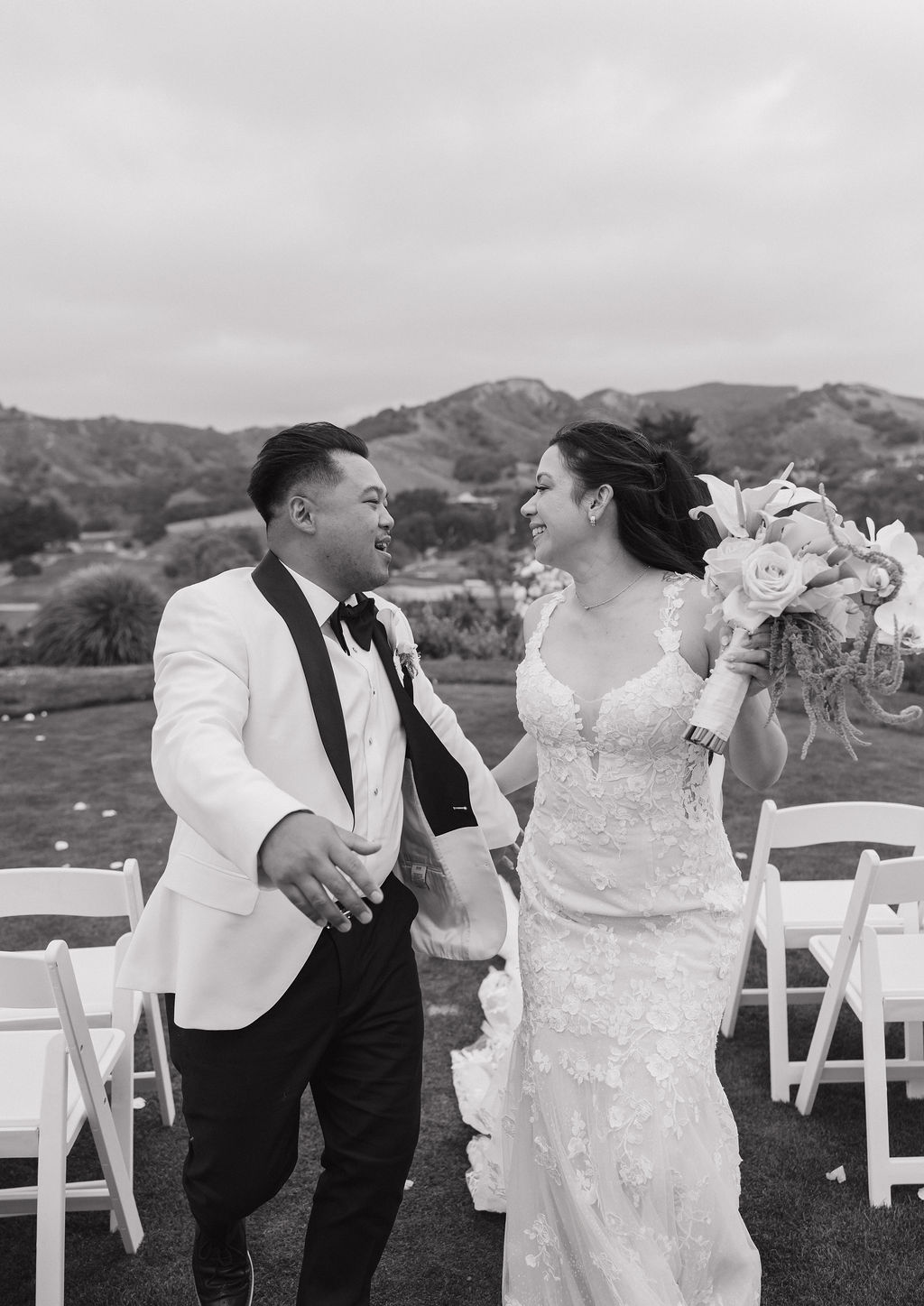 Bride and groom running and laughing down the aisle