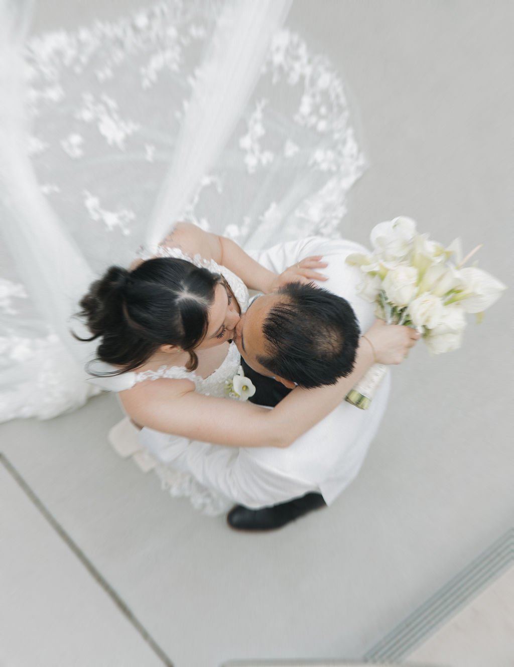 Arial editorial photo of bride and groom kissing