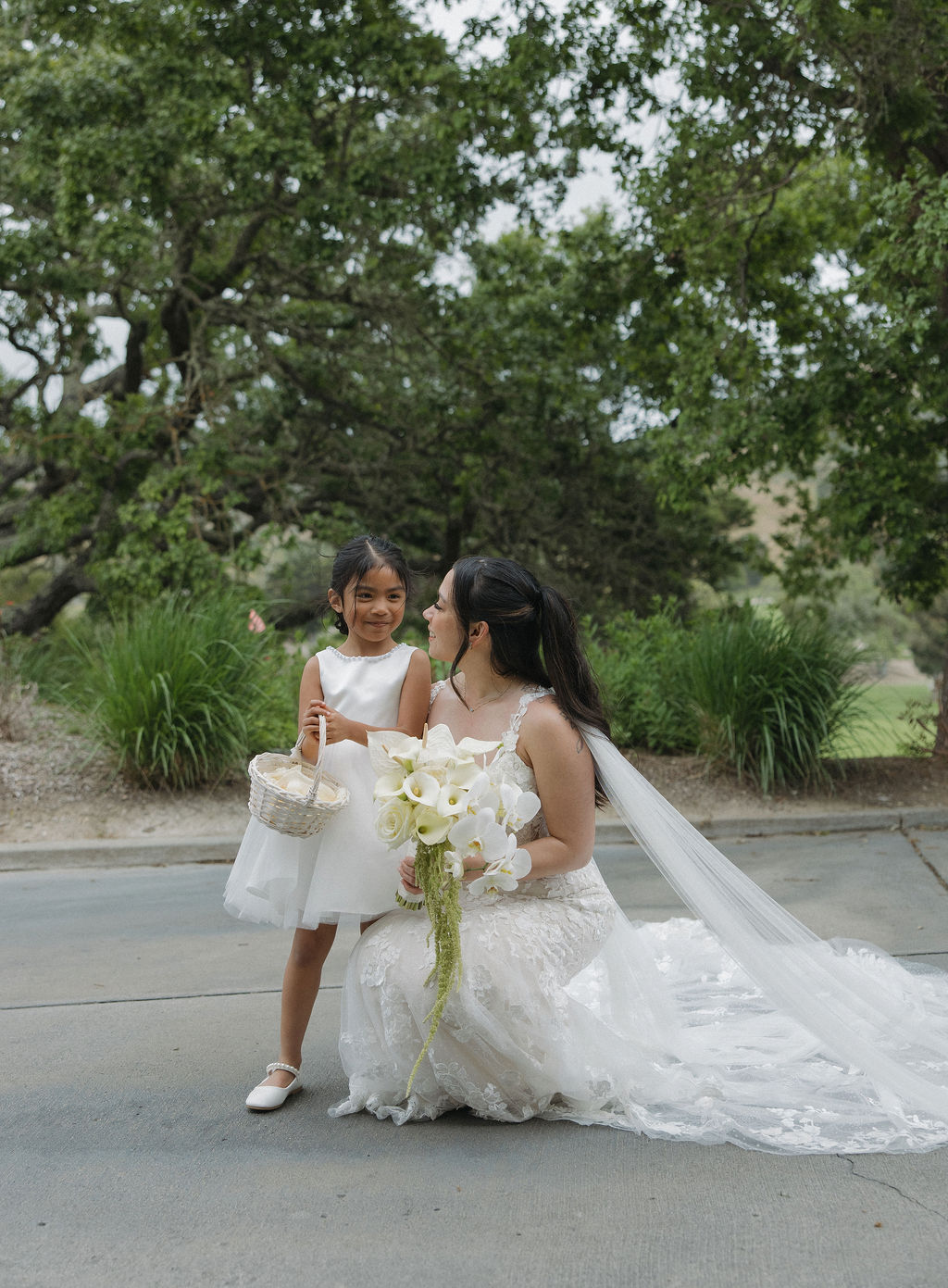 Bride with her flower girl posing for a picture
