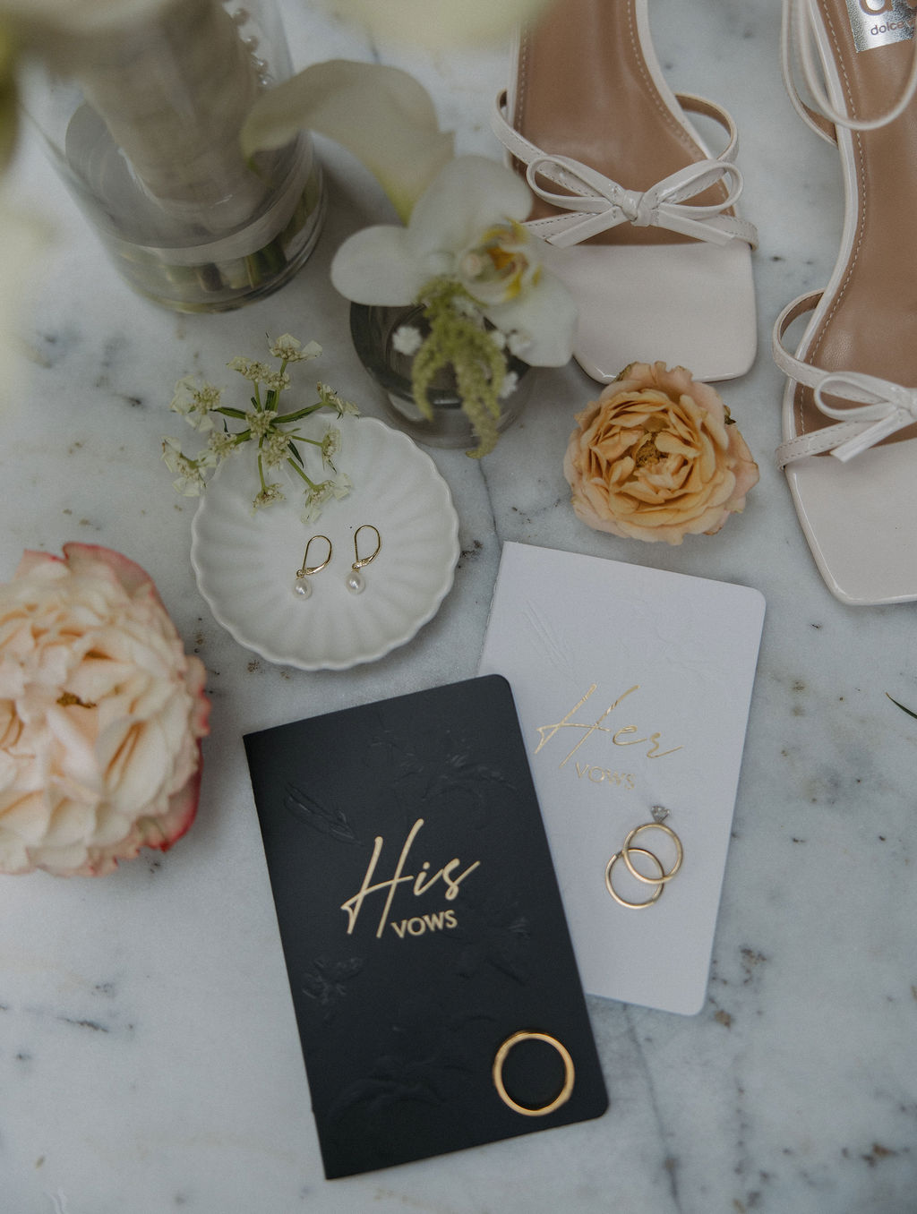 Wedding flat lay with vows, rings, wedding shoes, earrings, and wedding flowers