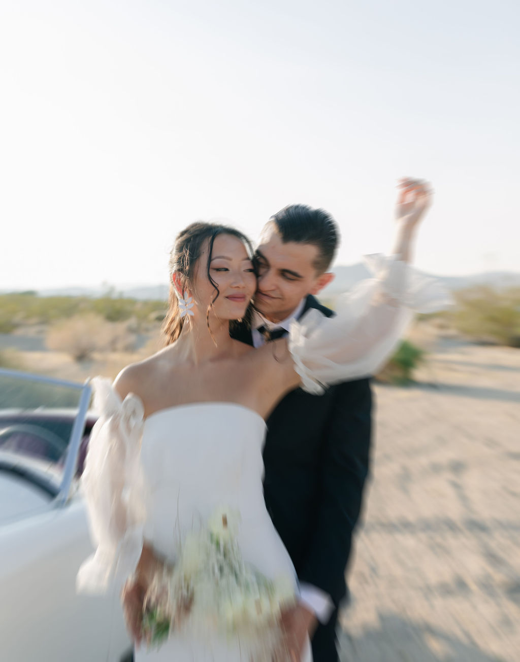 Blurry Joshua tree wedding photo with vintage car