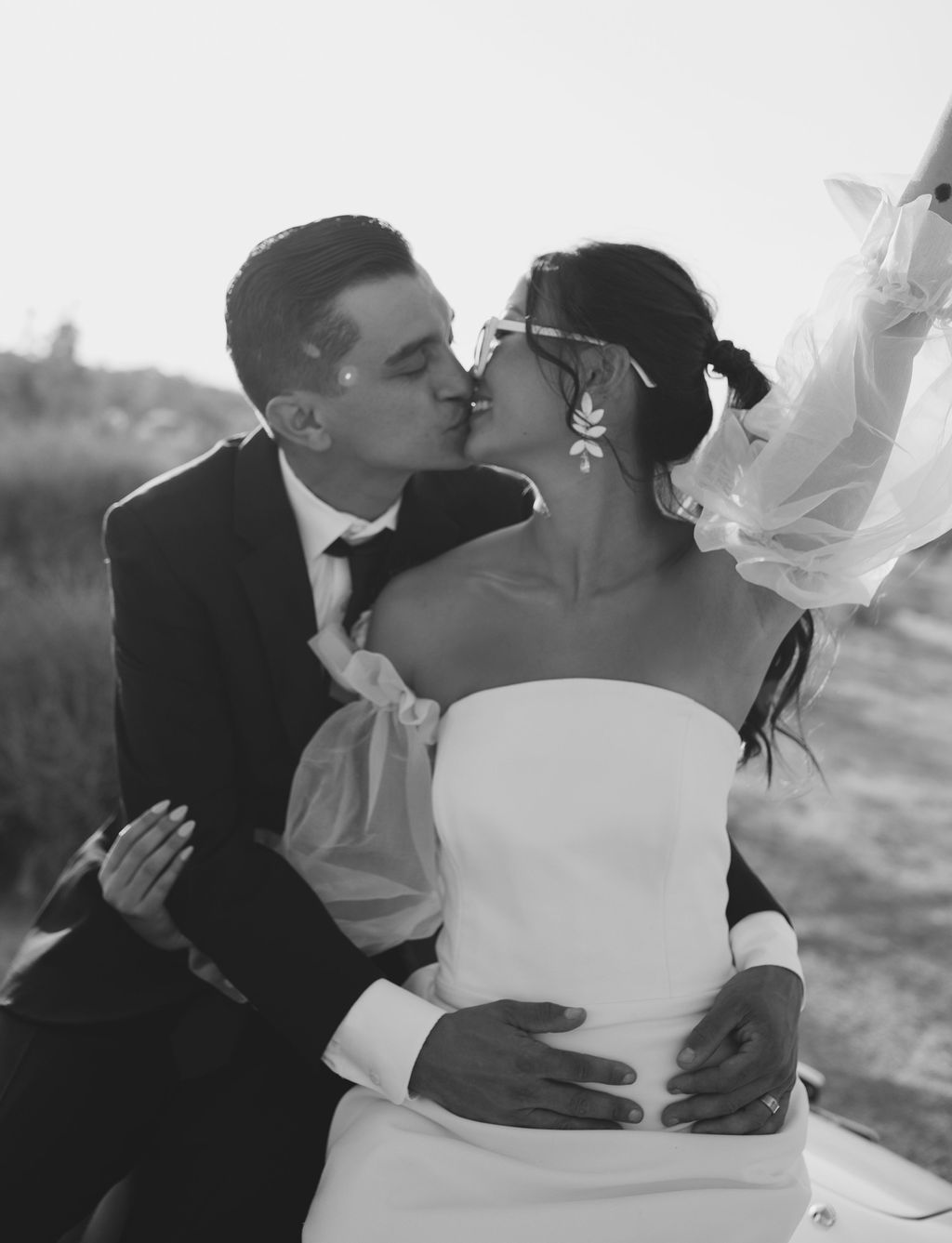 Black and white photo of bride and groom about to kiss with bride smiling