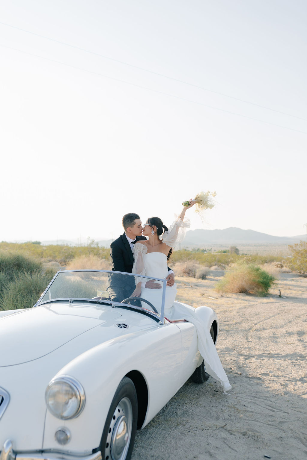 Bride and groom sitting in a vintage car in Joshua tree elopement