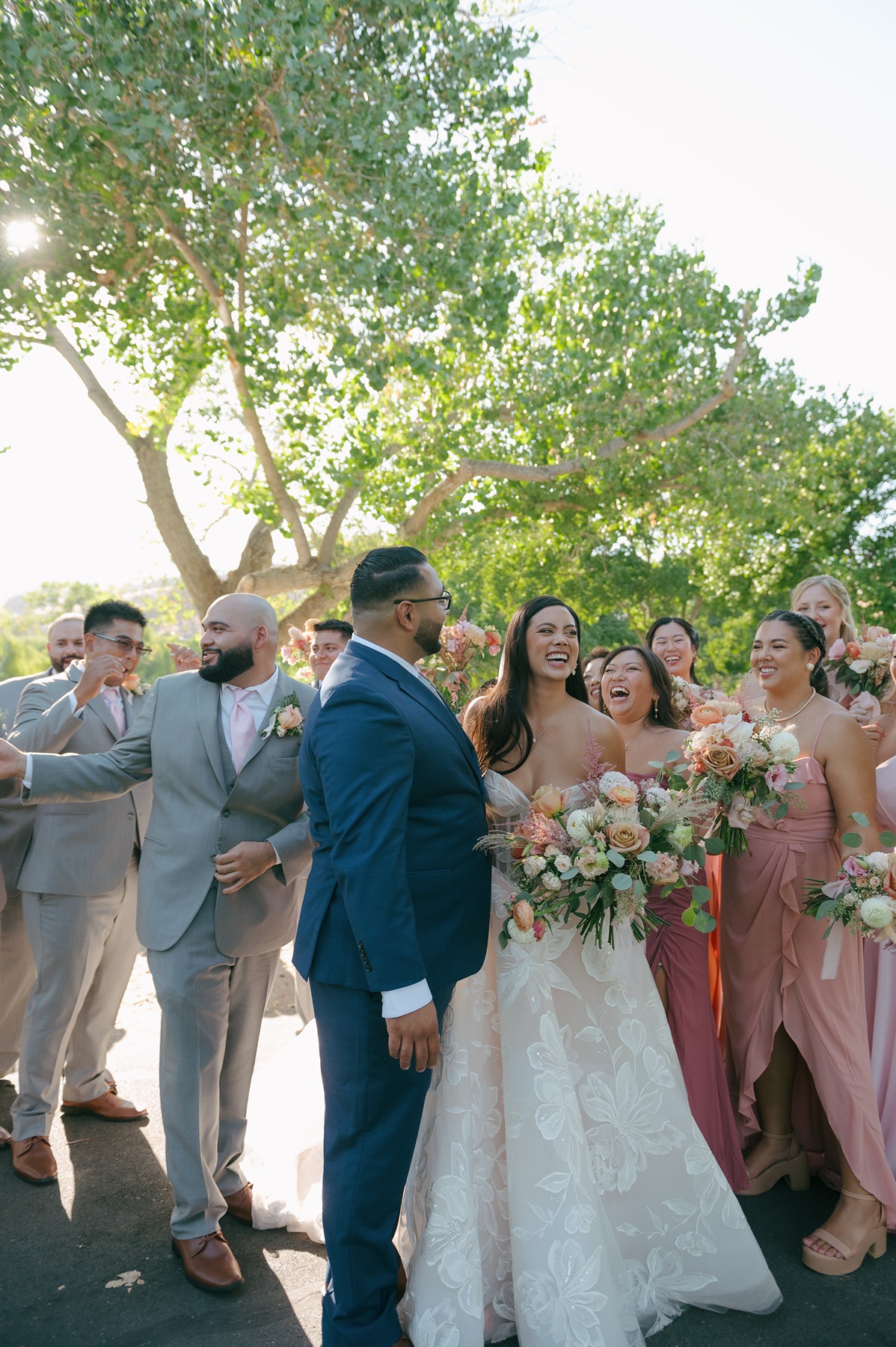 Bride and groom laughing with bridal party during bridal party photos