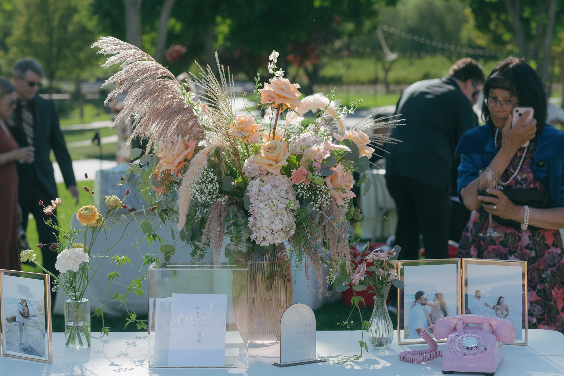 Wedding details with a floral arrangement and a phone guest book