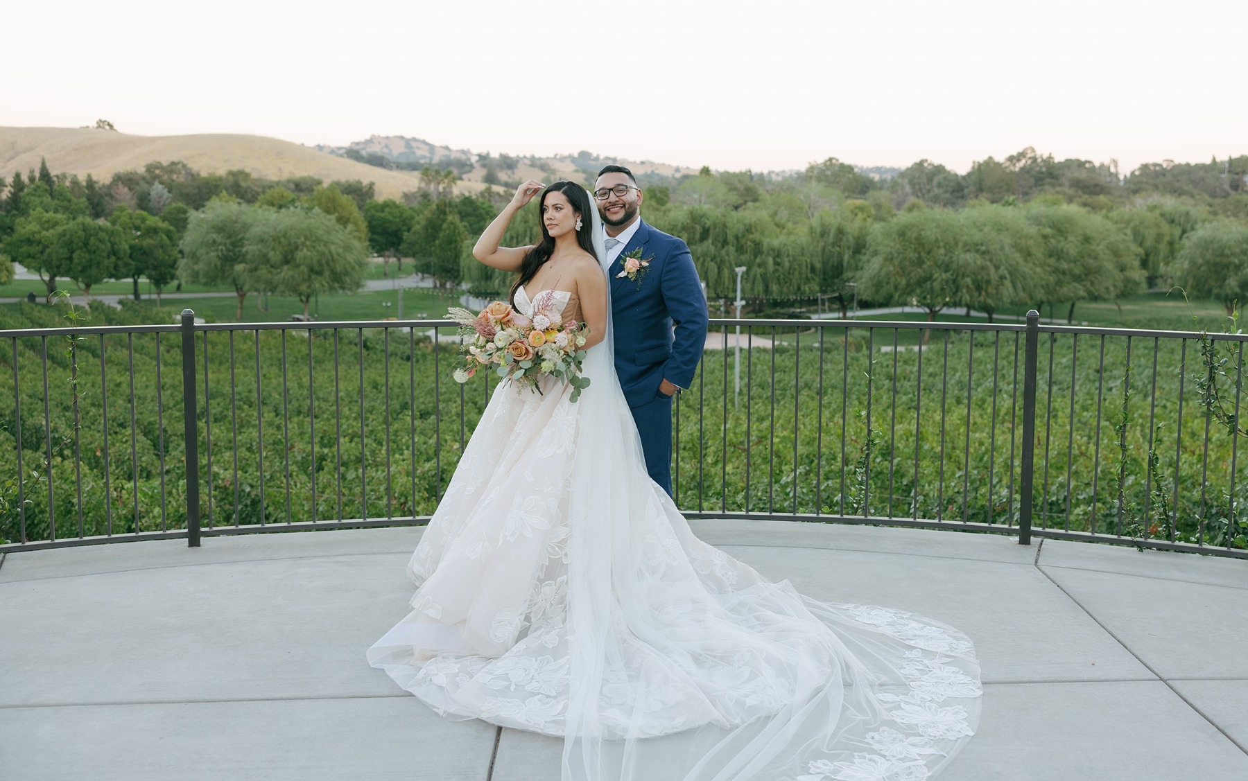 Landscape photo of bride and groom posing for editorial wedding photos at luxury wedding