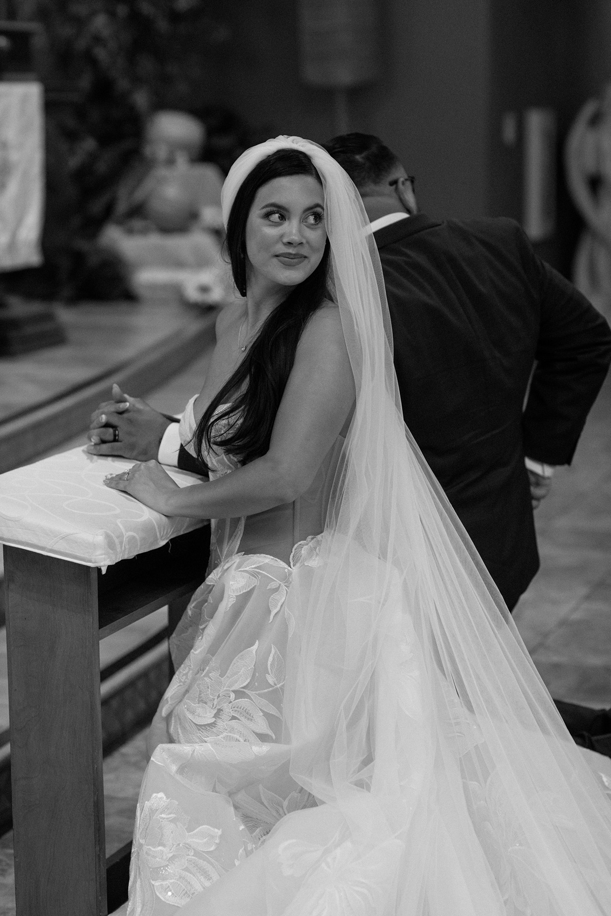 Wedding ceremony photos of bride looking behind her shoulder at the crowd in black and white