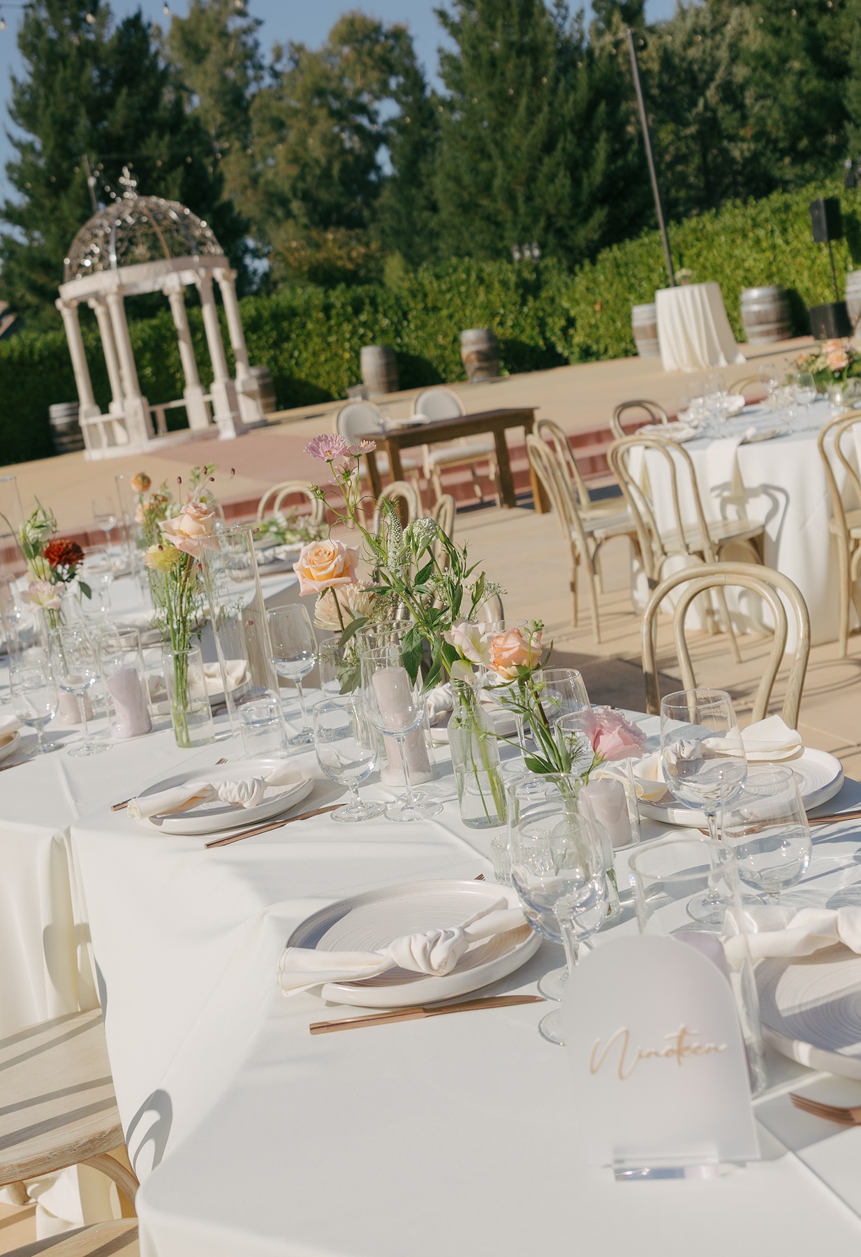 Wedding table setup with pastel wedding florals and curved wedding tables