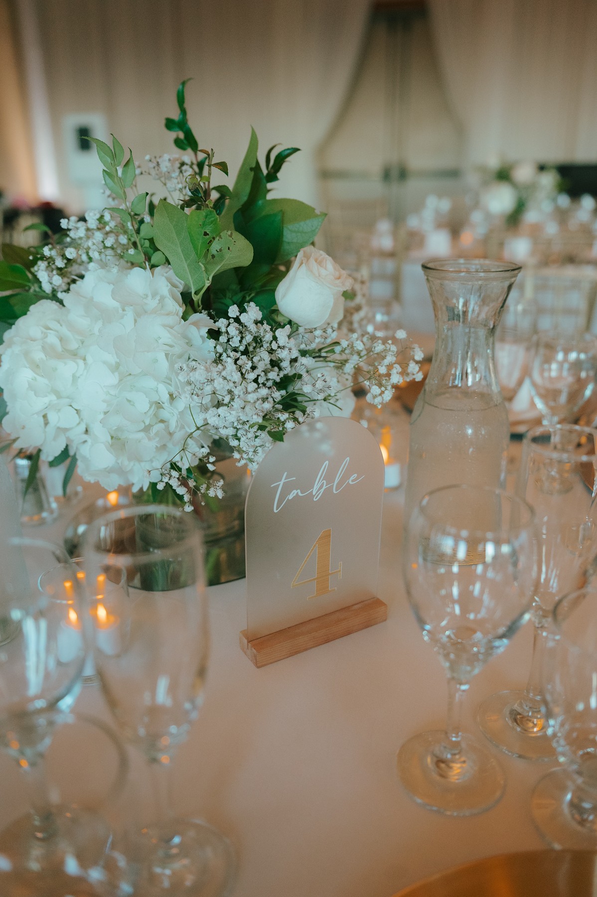 Wedding reception table setup with white floral centerpieces