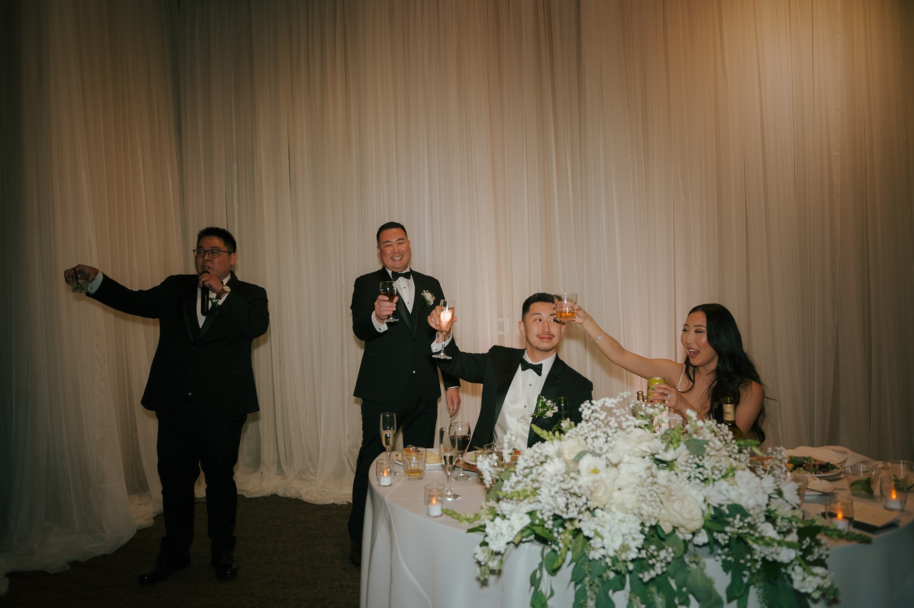 Bride and groom raising their glasses for a toast