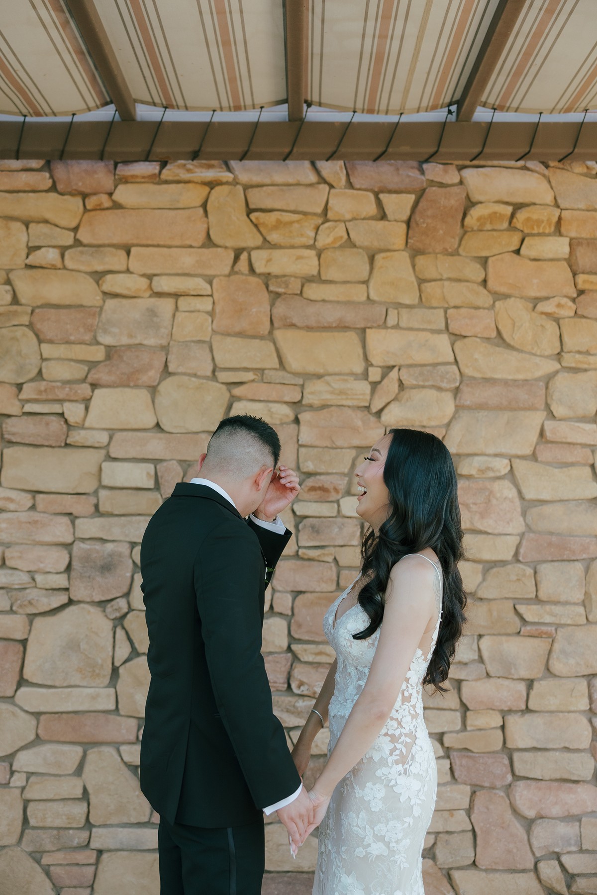 Bride laughing and groom crying during first look wedding photos