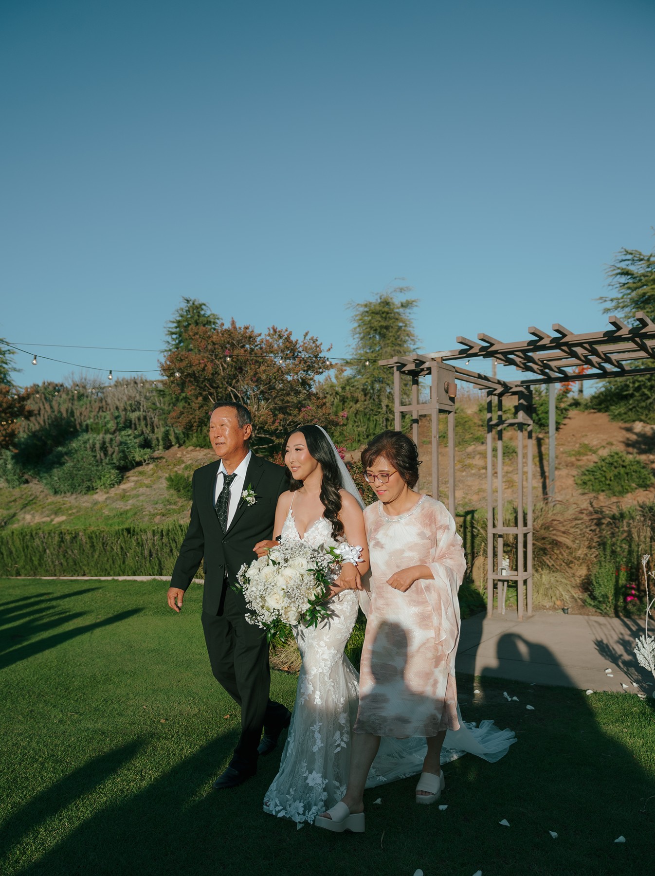 Bride's parents walking her down the aisle for her wedding ceremony