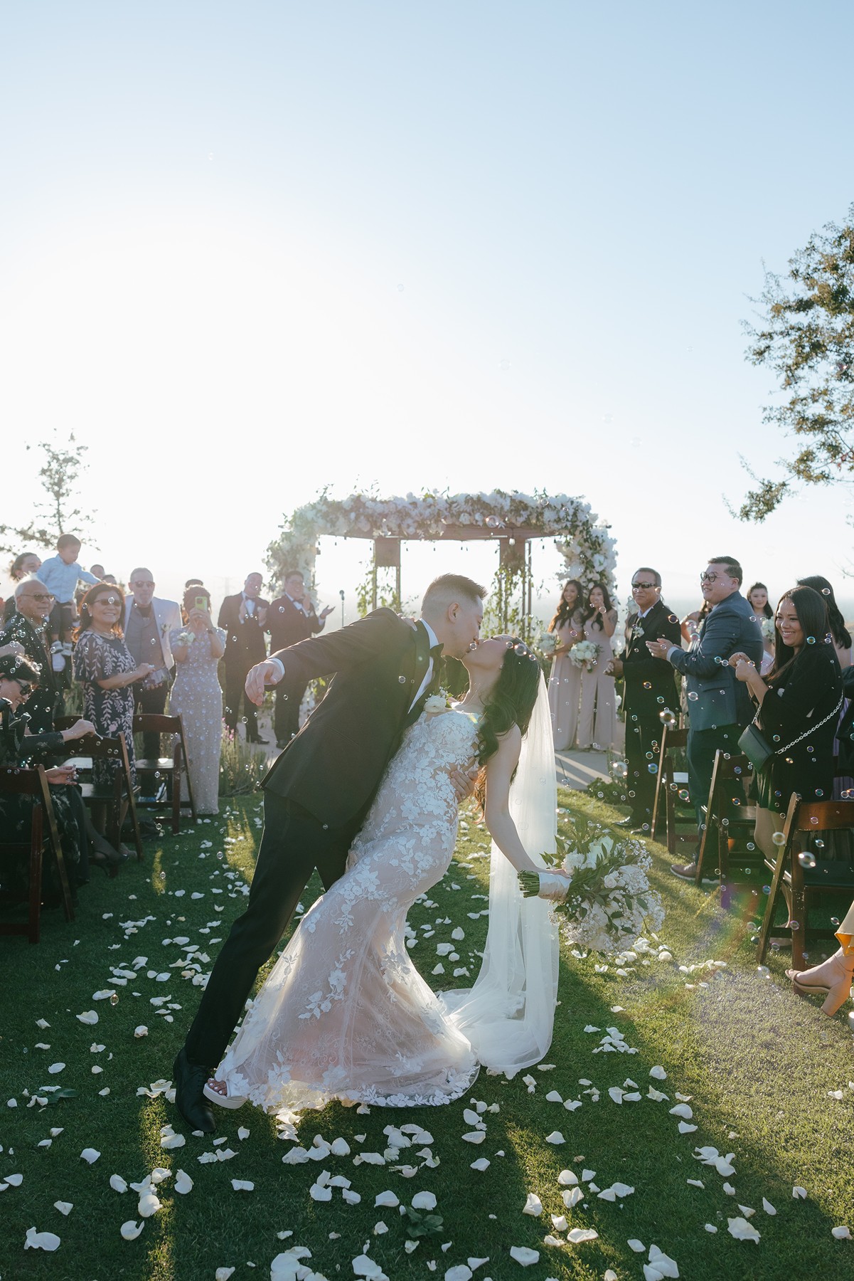 Bride and groom dip kissing after their ceremont