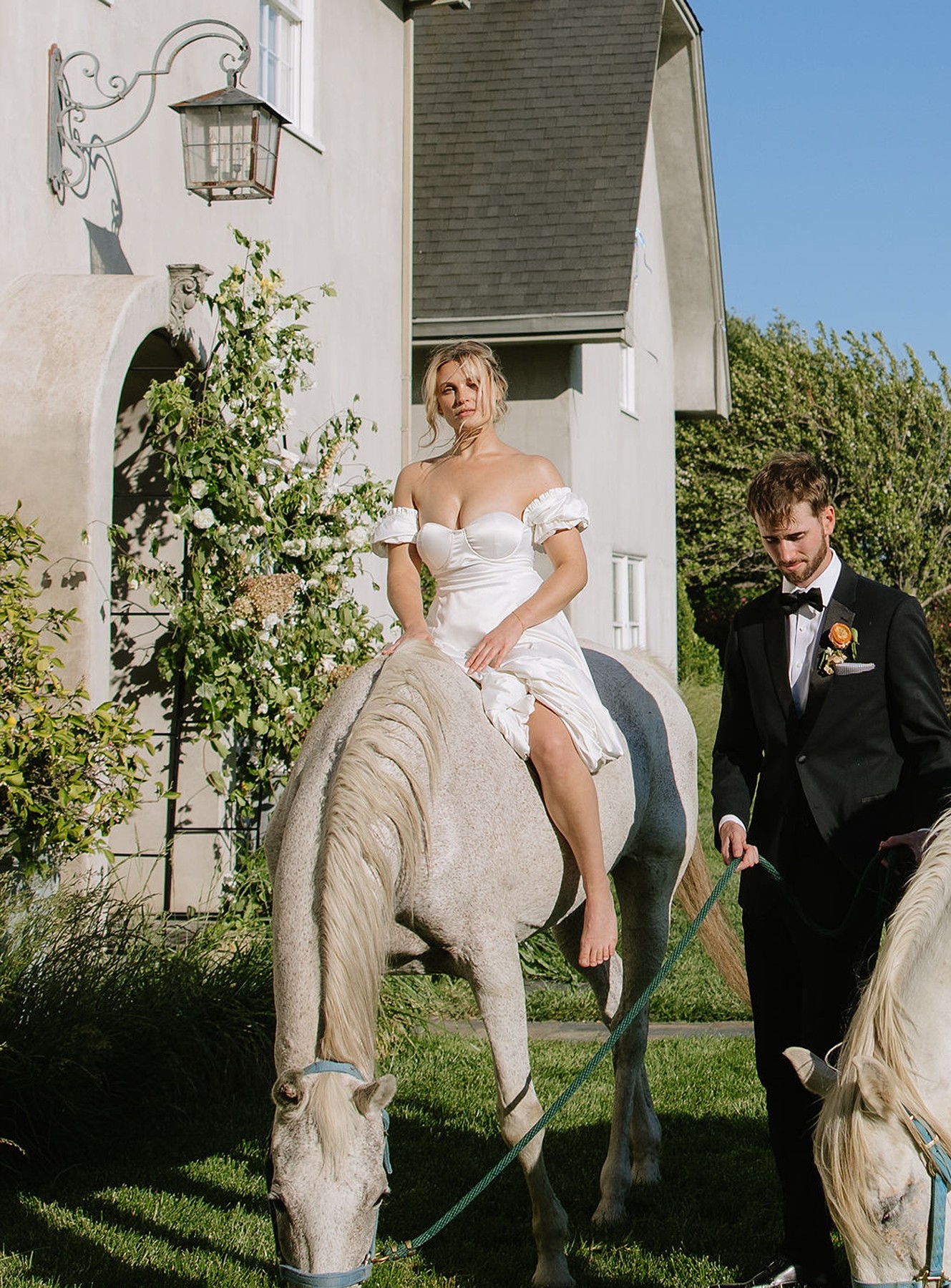 Bride riding a horse in wedding photos with groom walking beside her