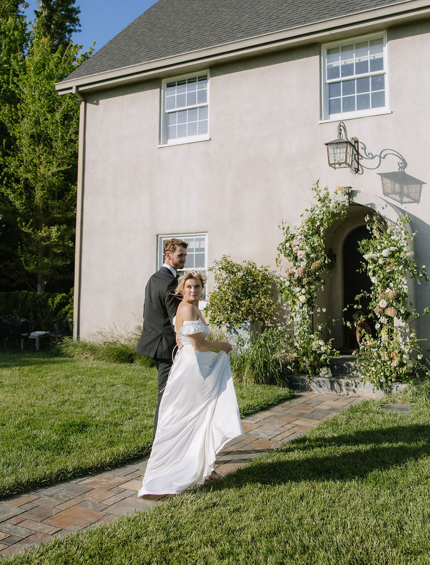 Couple walking away form camera with bride turned looking over her shoulder