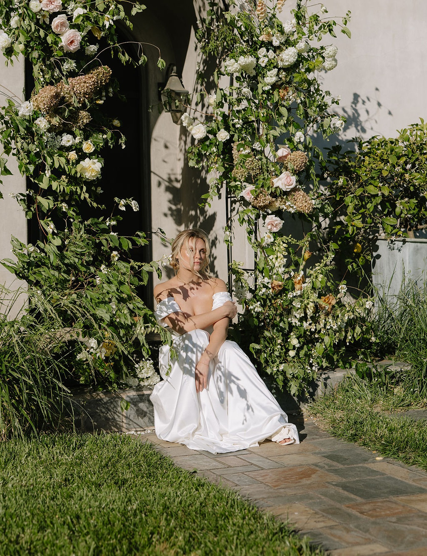 Bridal portraits underneath a white and green floral arch in front of Cavaignac, a country estate