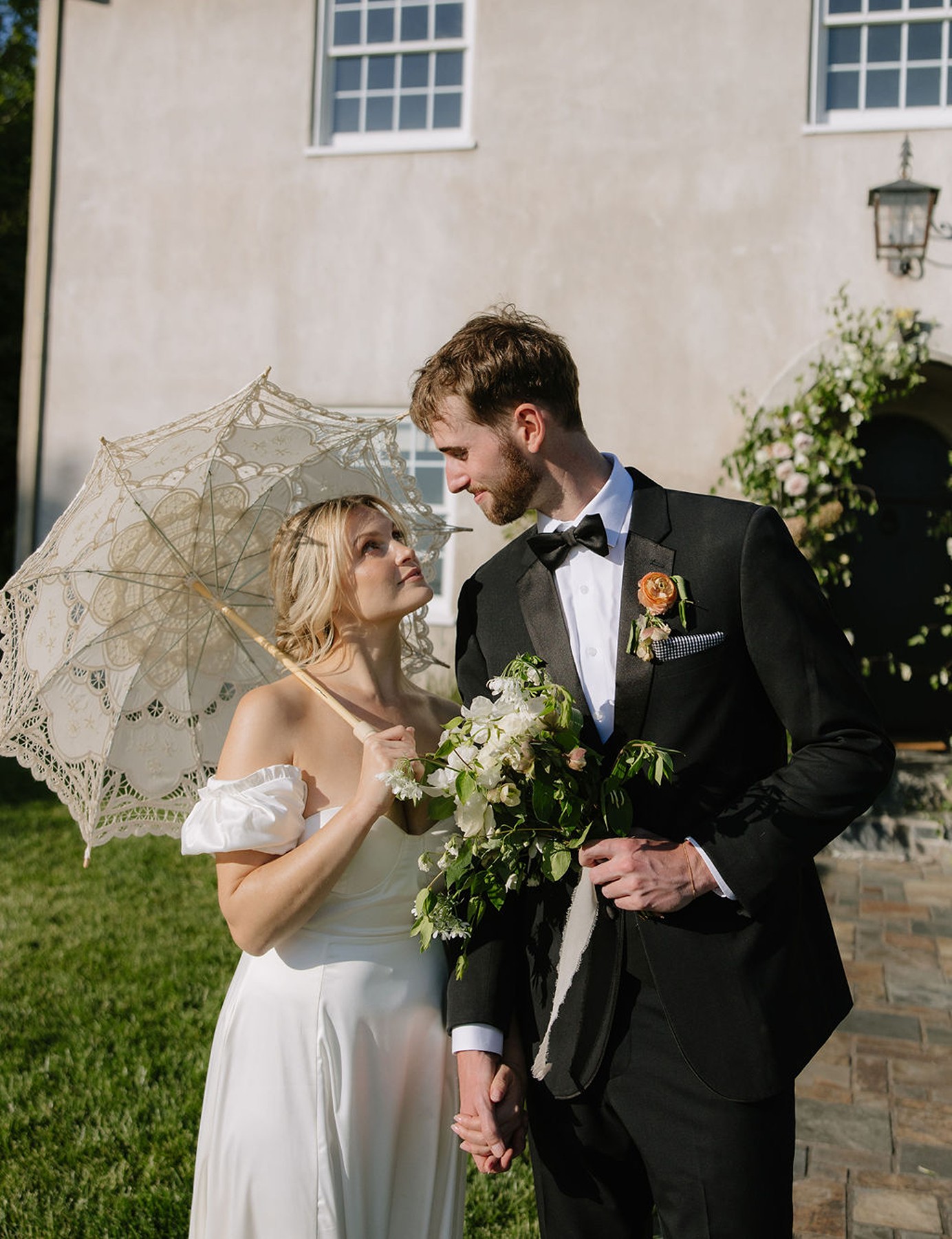 Couple looking at each other posing with a parasol for wedding photos