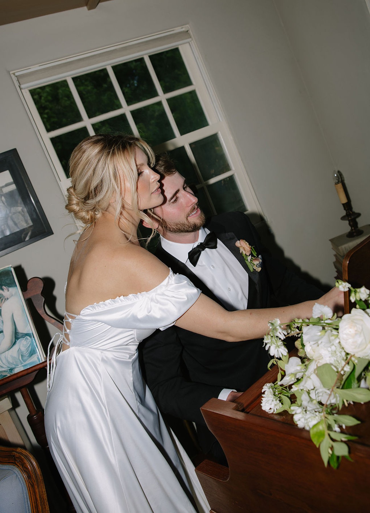 Couple posing by a piano in direct flash wedding photo