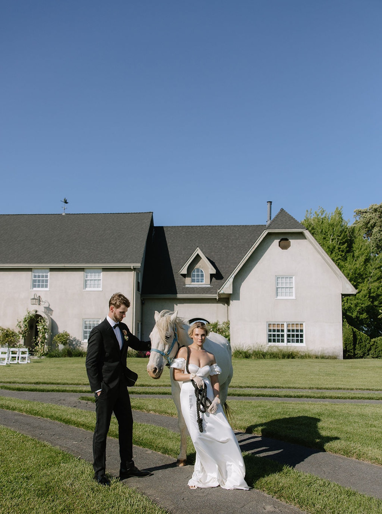 Couple posing for wedding photos with a horse in front of Cavaignac, a country estate