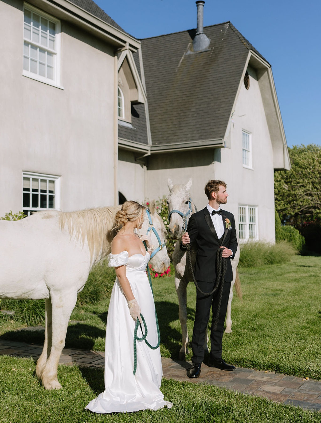 Couple posing with a horse in front of a country estate