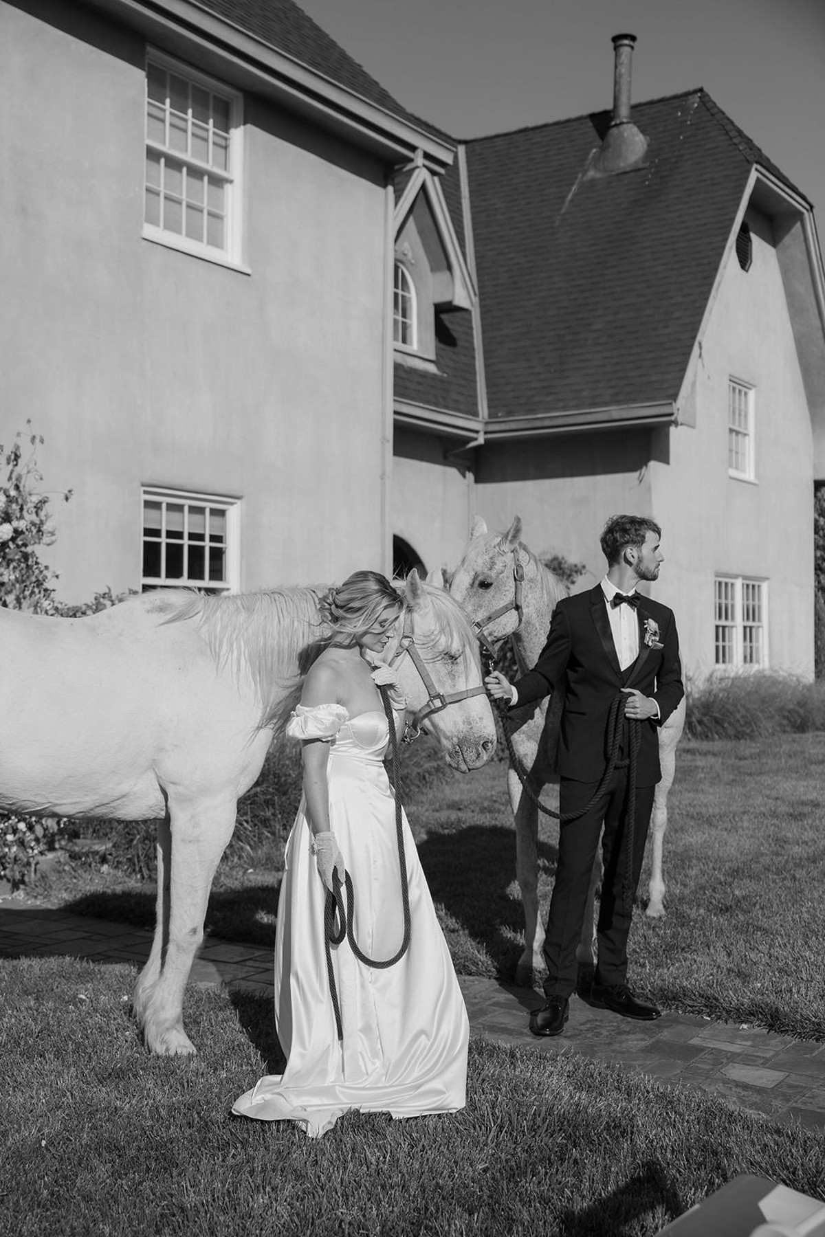 Bride and groom posing with a horse for editorial European-inspired wedding