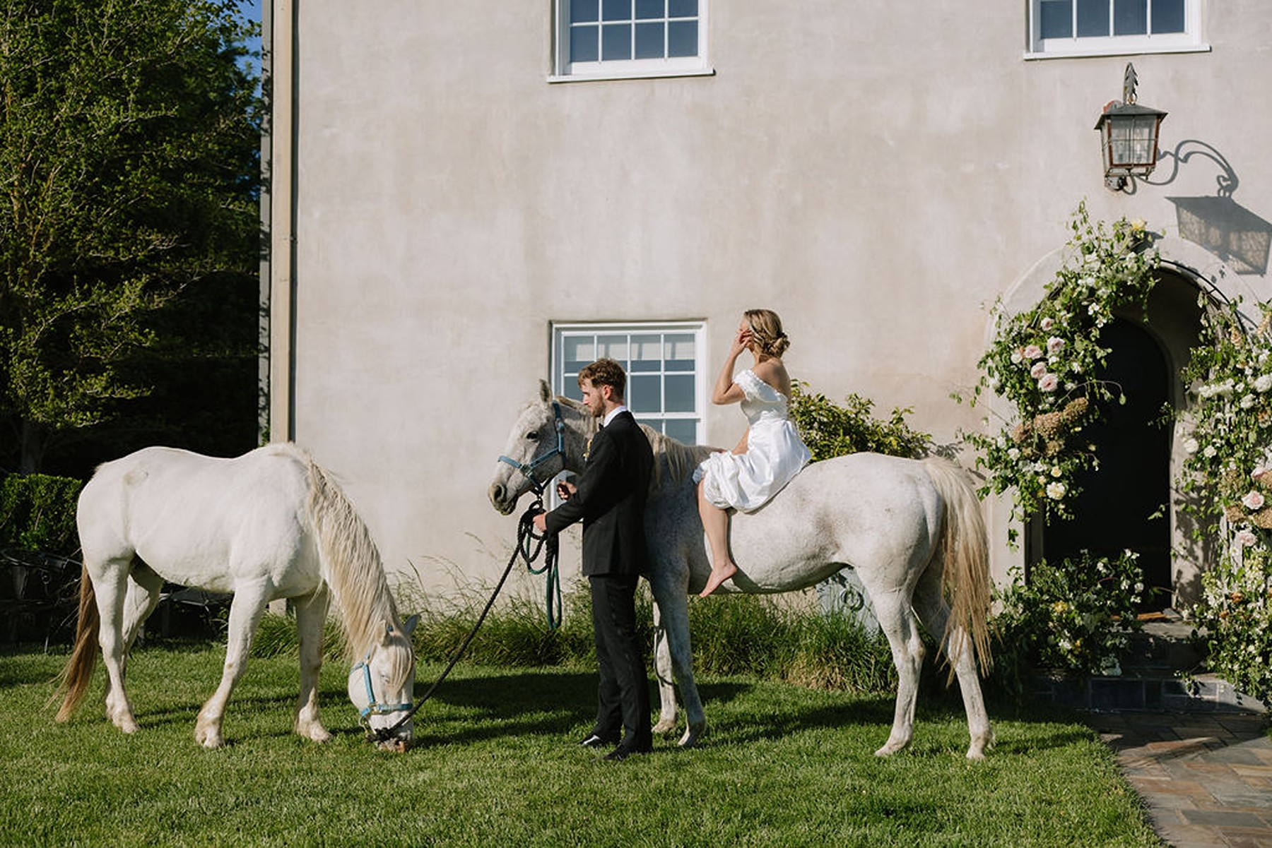 Bride and groom with horses in front of a country estate wedding venue